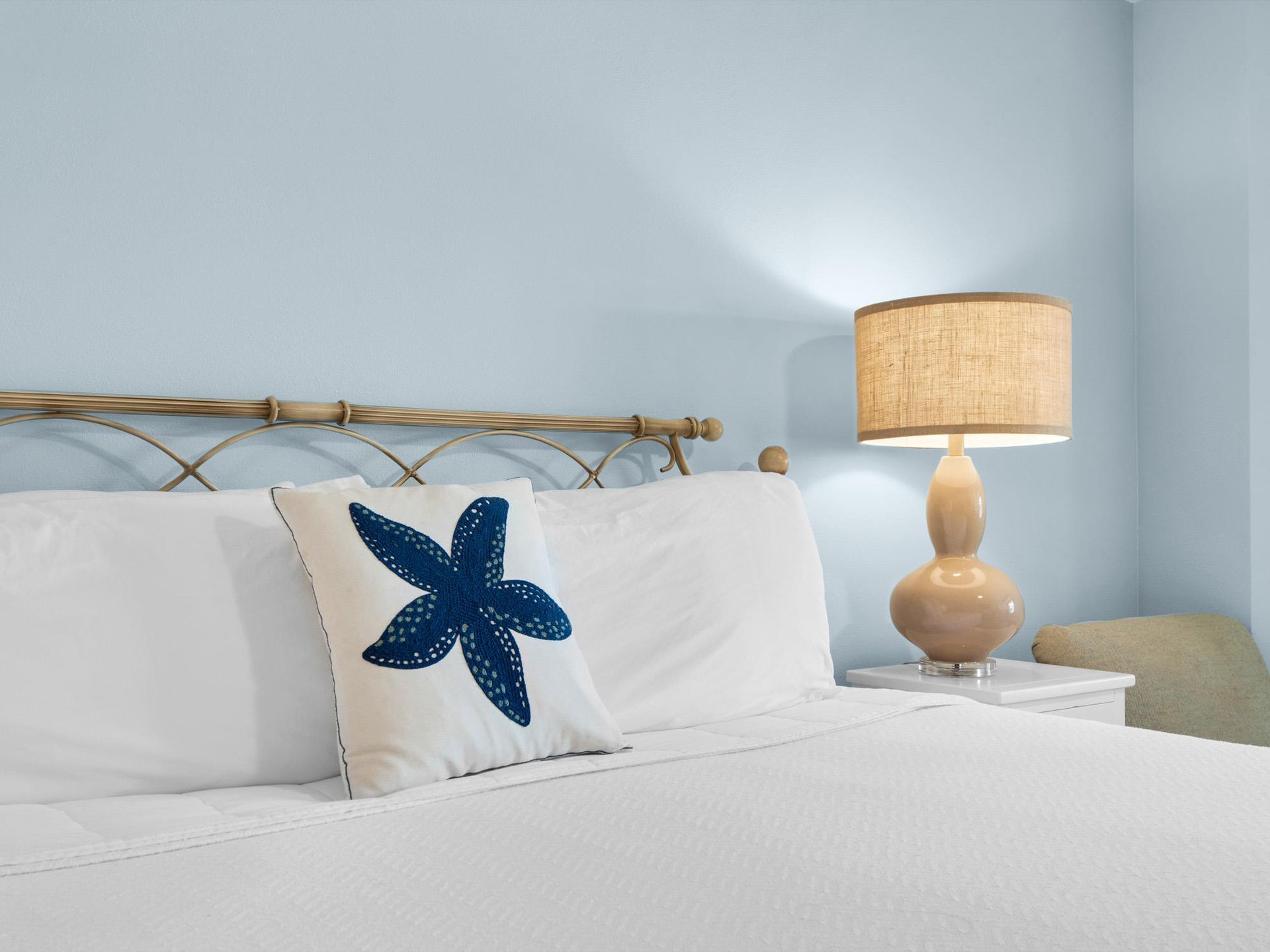 Drift off in this peaceful bedroom where coastal charm meets comfort. Crisp linens and warm lighting create your perfect seaside retreat.