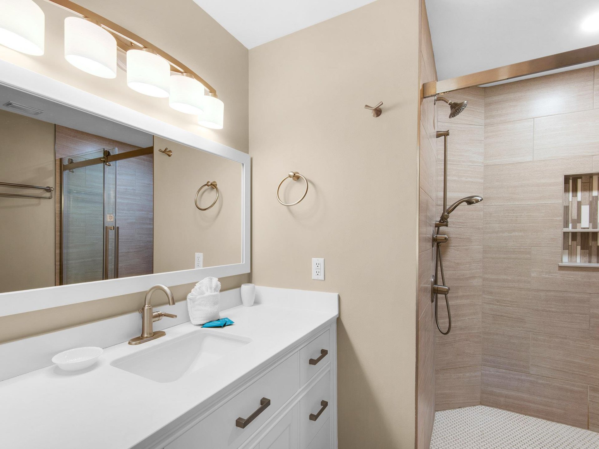 Step into your modern bathroom featuring a sleek vanity, spacious walkin shower, and plenty of fresh towels for your comfort.
