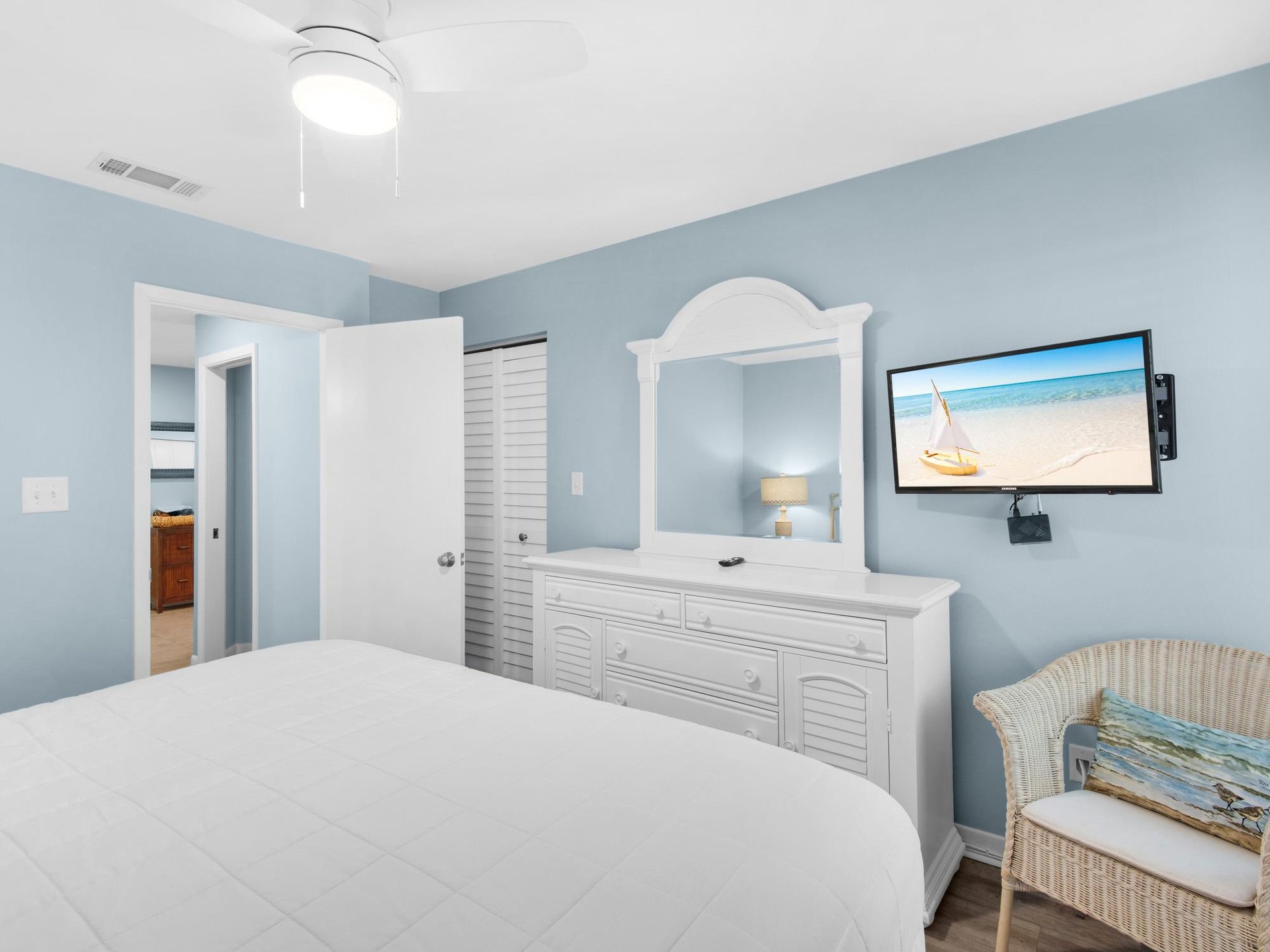 Drift off in your serene coastal bedroom, where soft blue walls and white furnishings create the perfect seaside escape for peaceful nights.