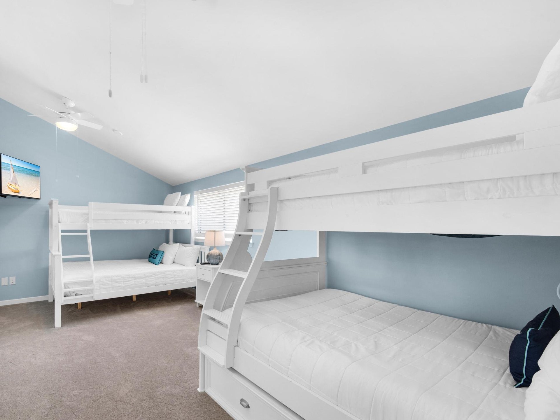 Your kids will love this bright bunk room with custom white beds and plenty of space to play and rest.