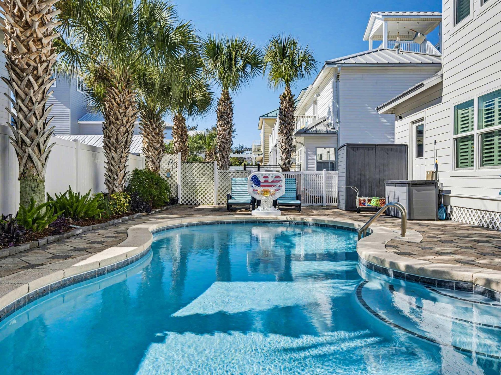 Dive into your private oasis featuring a sparkling pool, surrounded by tropical palms and coastal charm.