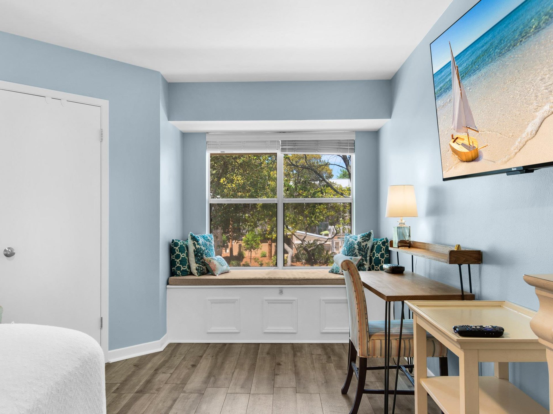 Unwind by your cozy window seat surrounded by soothing coastal blues and modern workspace amenities.