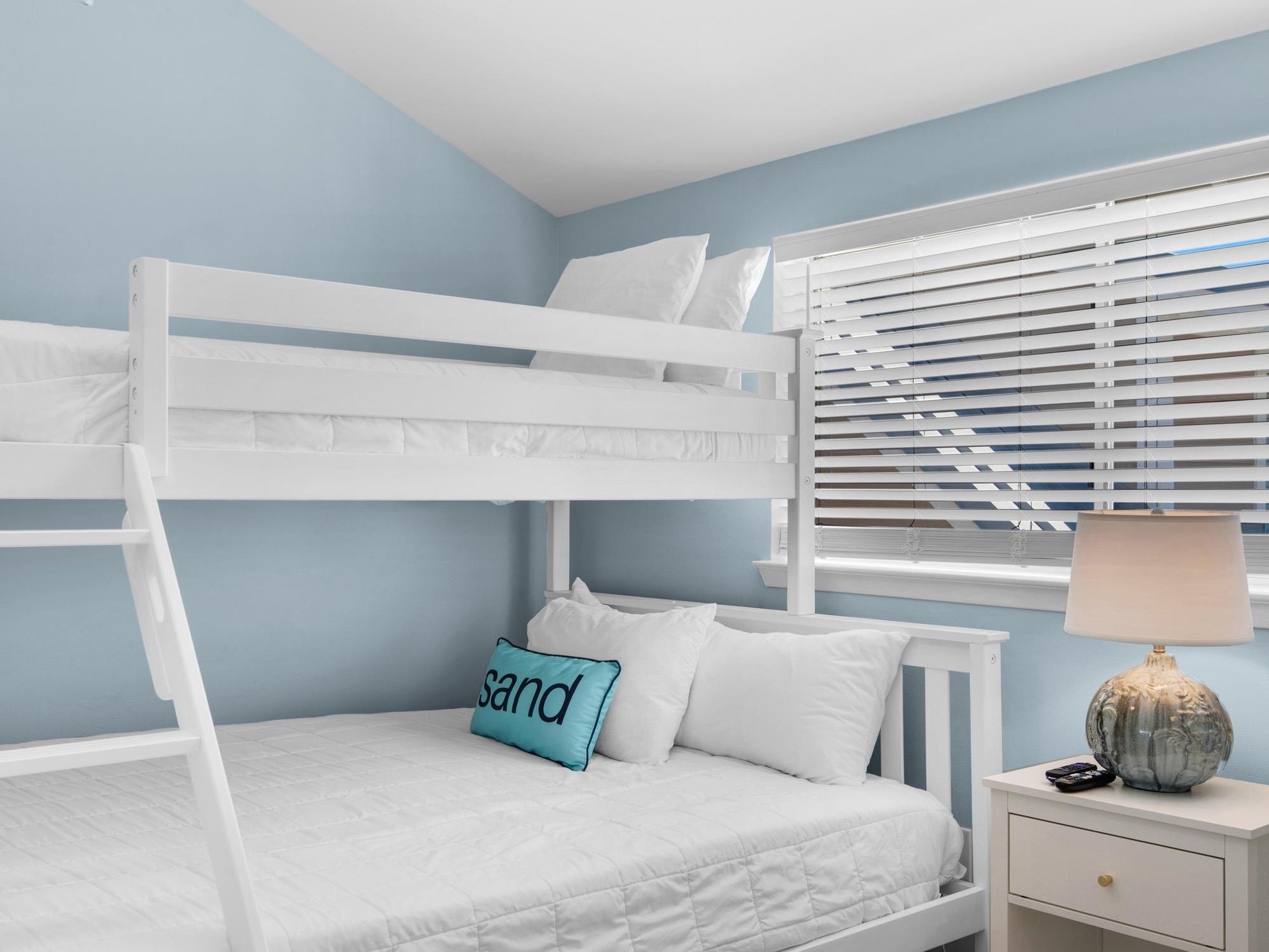 Your beachthemed bedroom features crisp white bunk beds with soft linens, perfect for family stays.
