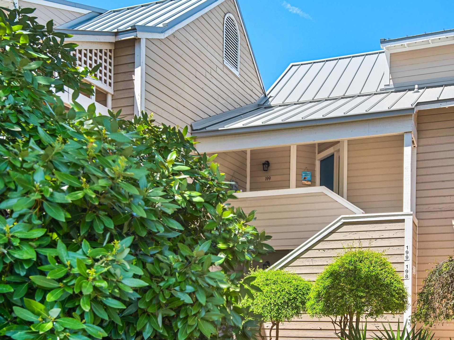 Charming vacation rental buildings nestled among mature trees.