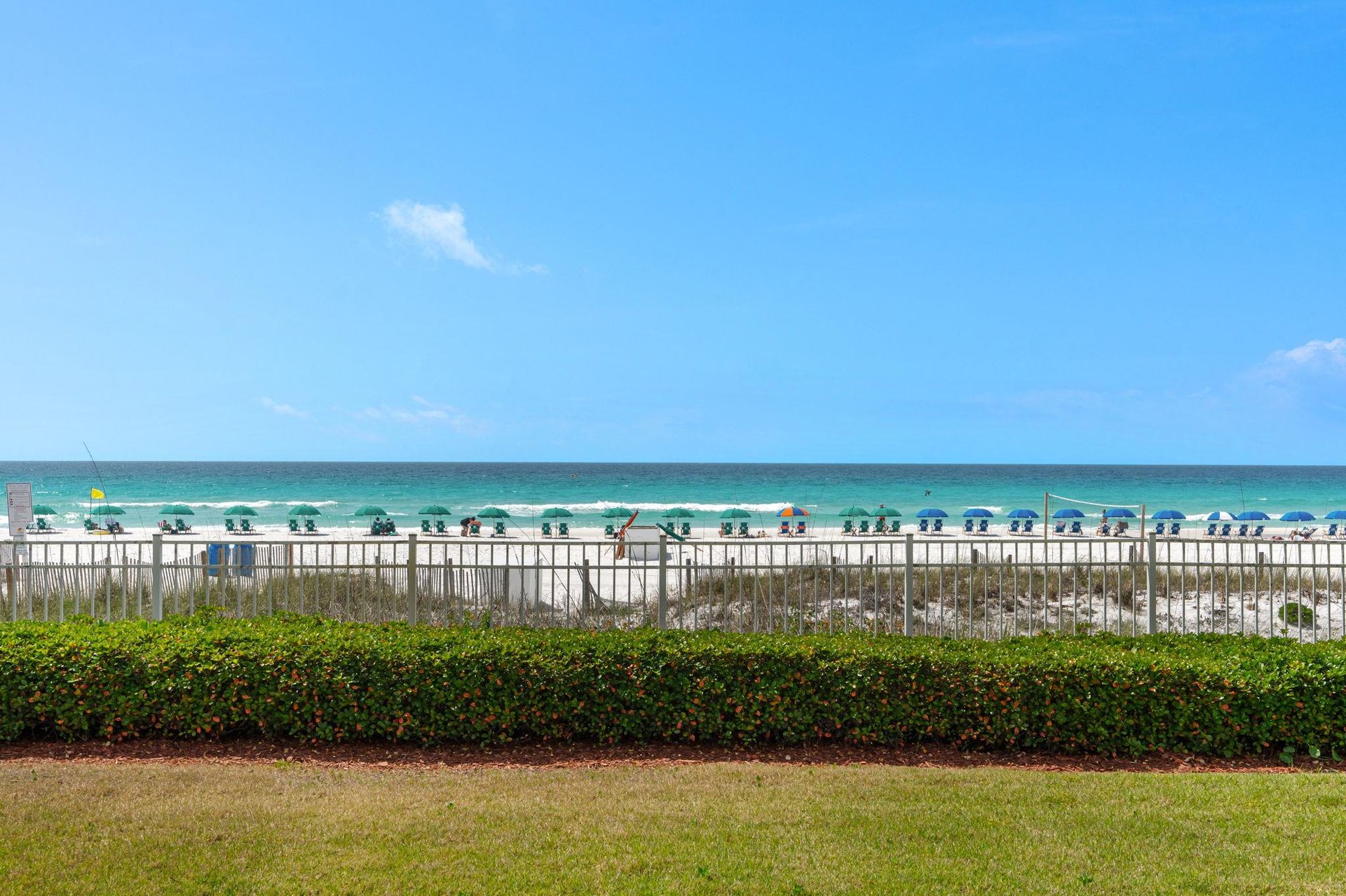 Pristine white sand beach with emerald waters stretches beyond the property grounds, offering direct beachfront access.