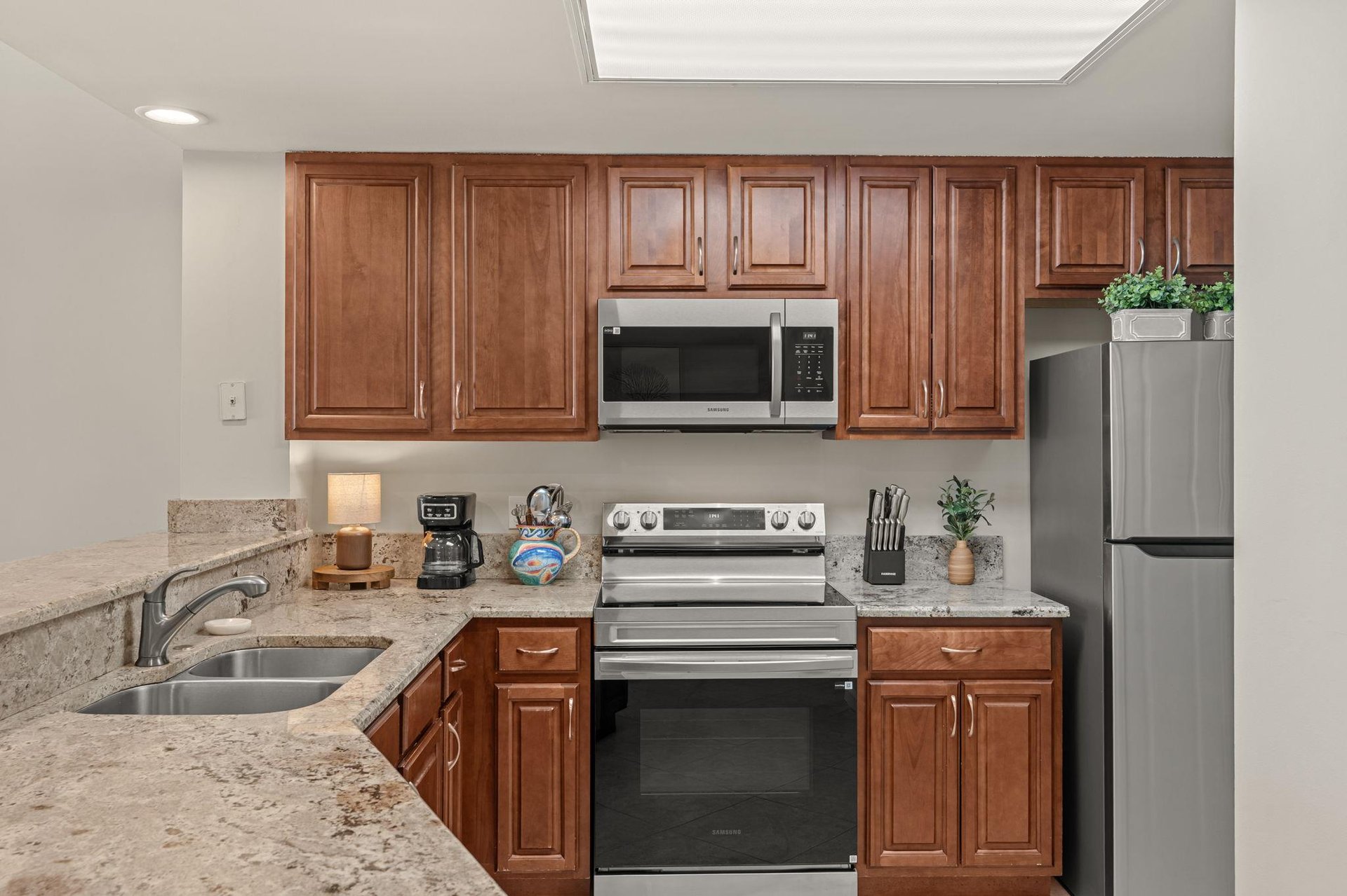 Your fully equipped kitchen features granite countertops, stainless steel appliances, and warm wood cabinetry for creating memorable meals.