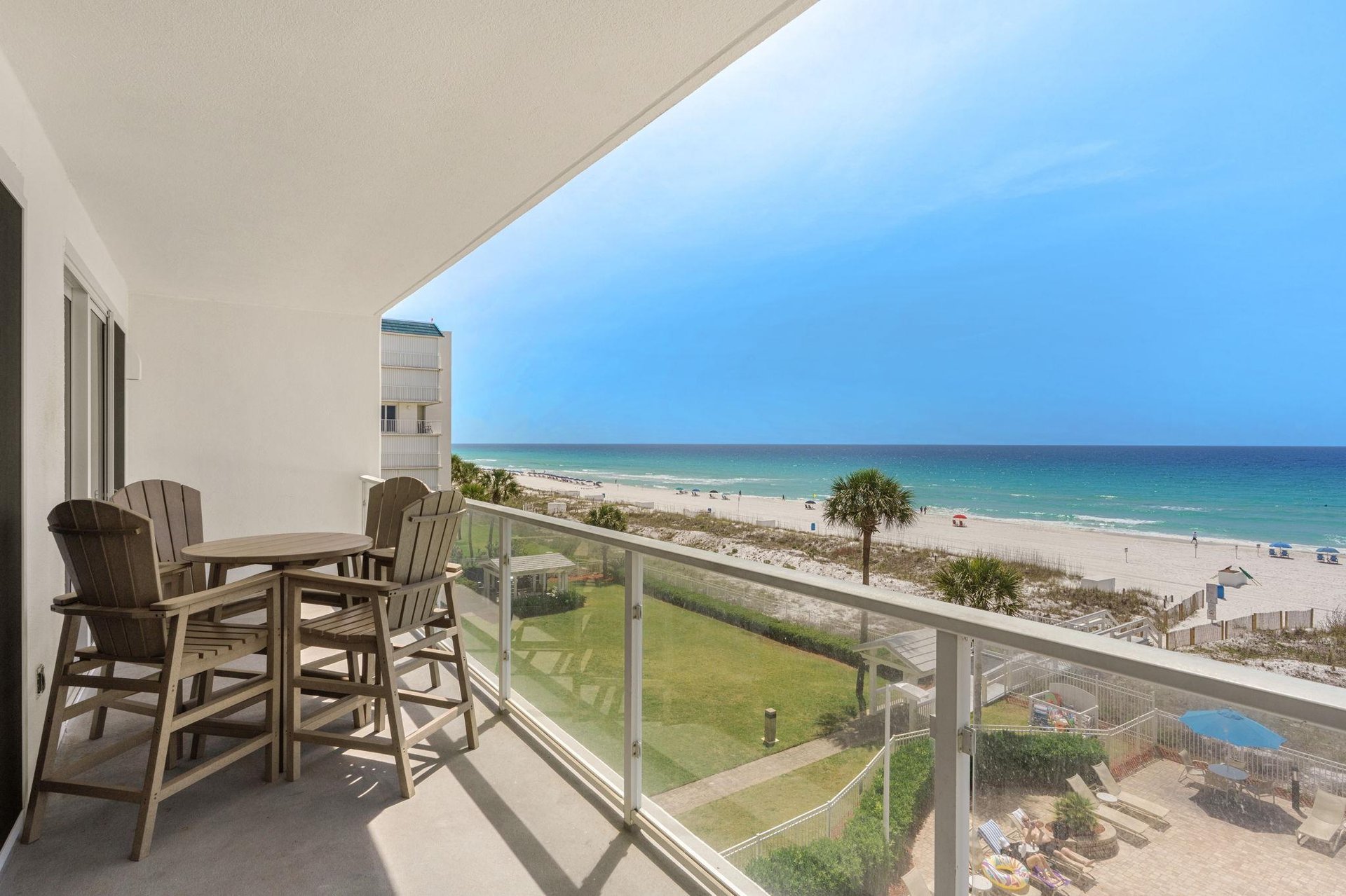 Stunning beachfront balcony with direct ocean views and comfortable outdoor dining setup.