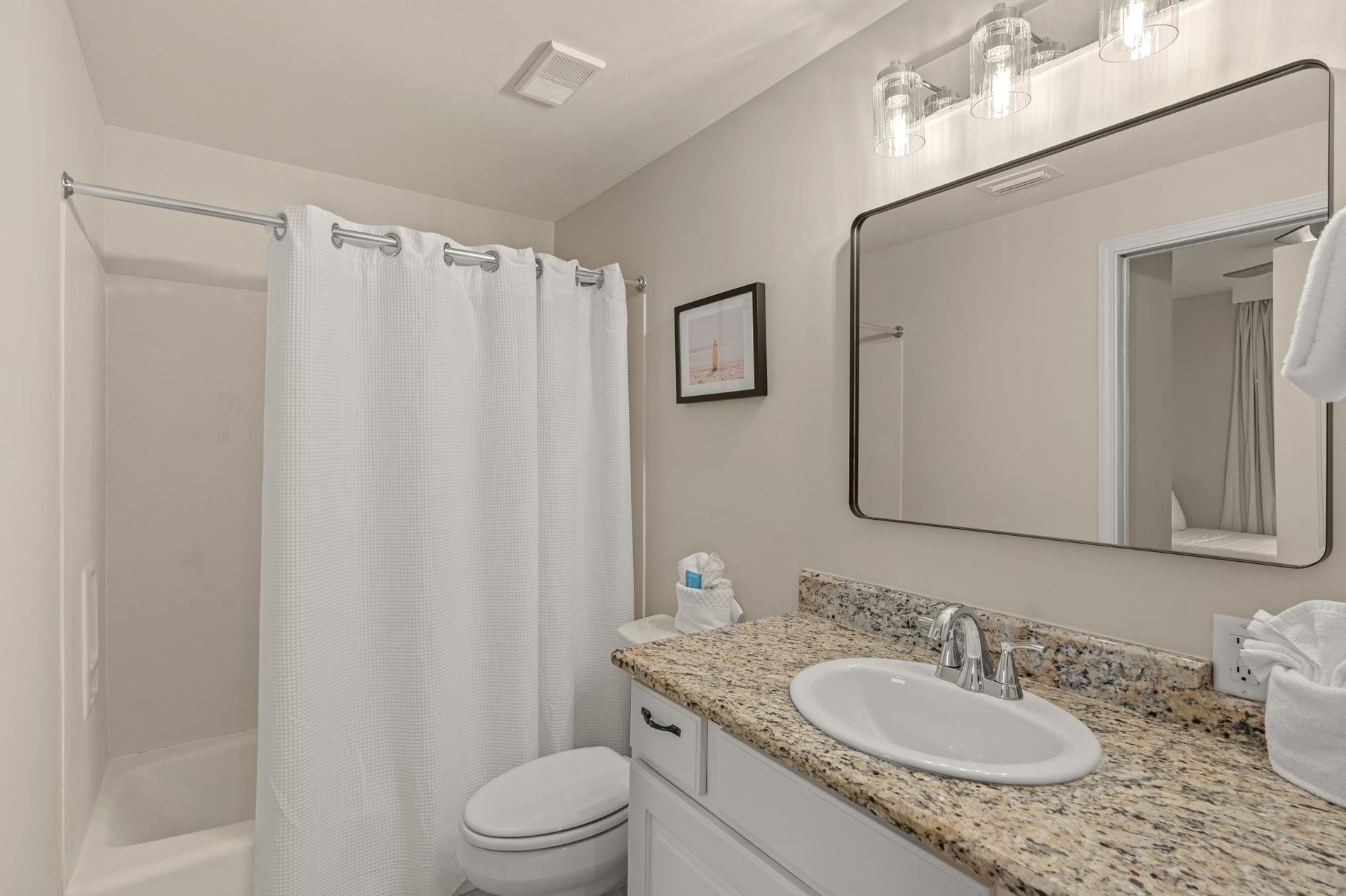 Step into your sparkling clean bathroom featuring granite countertops, elegant lighting, and fresh towels waiting for you.