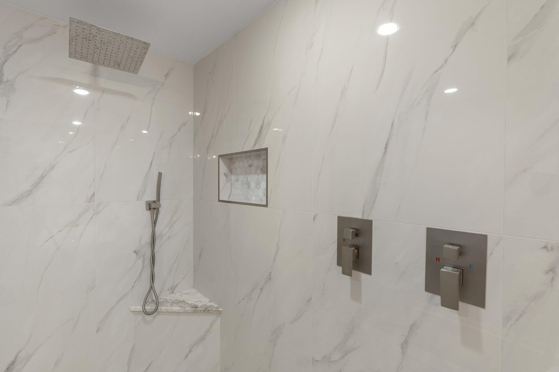 Step into your luxurious marble shower with rainfall head and handheld wand  perfect for unwinding after exploring.