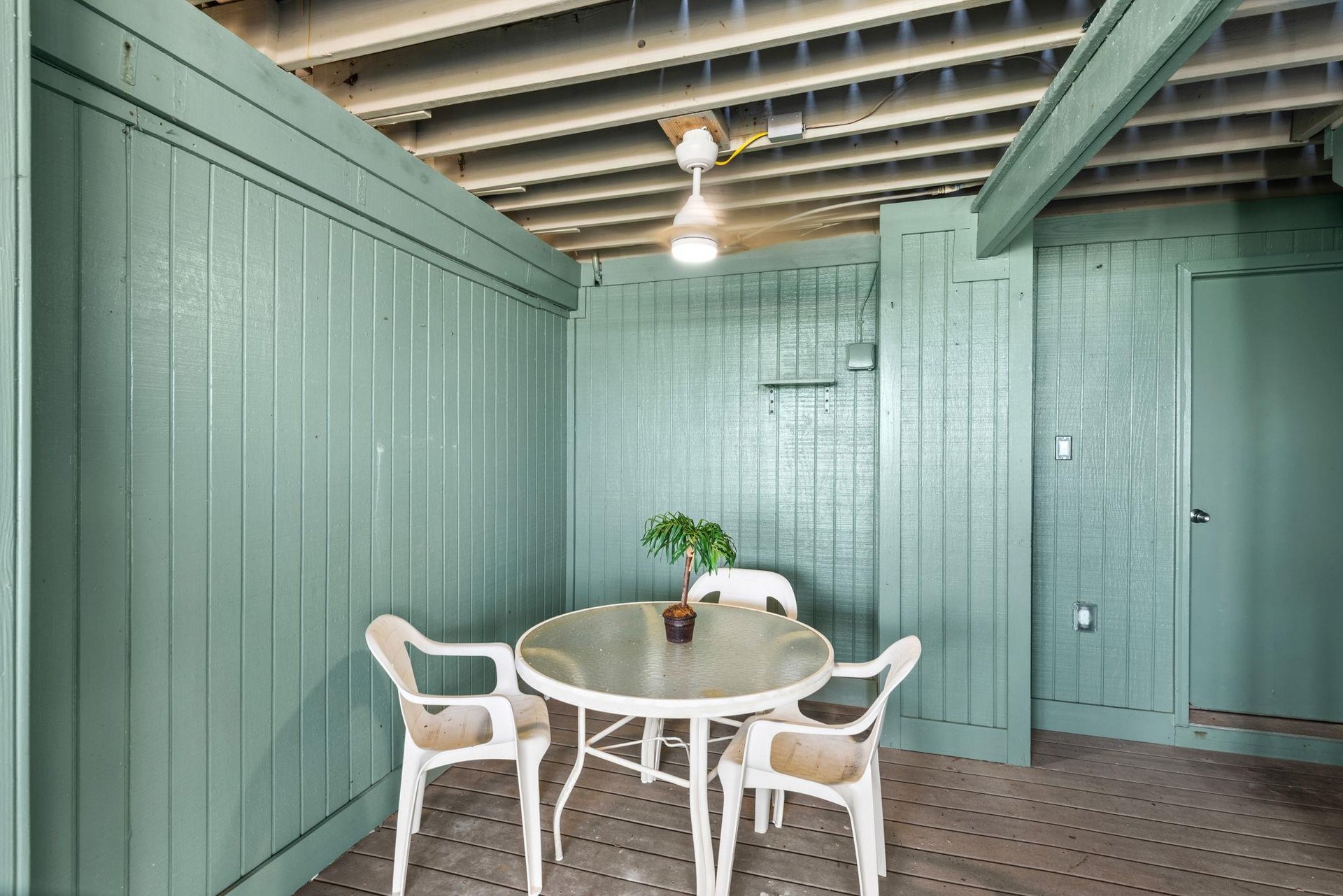 Covered patio with table and chairs for card games or cocktails and an outdoor shower to rinse the days sand away