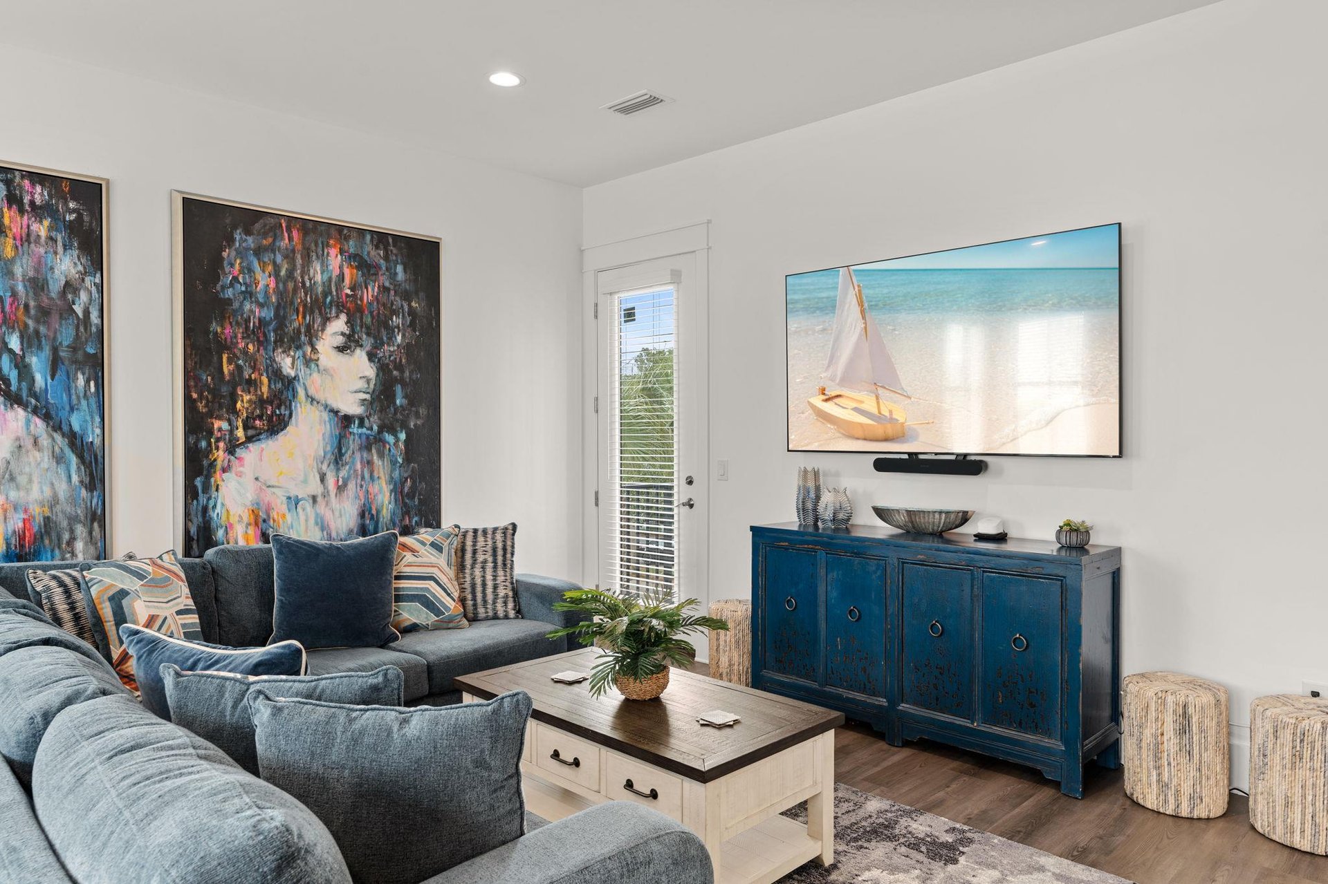 Sink into plush sofas and unwind in your bright, artfilled living space where coastal vibes meet modern comfort—perfect for your next bingewatch or quiet moment.