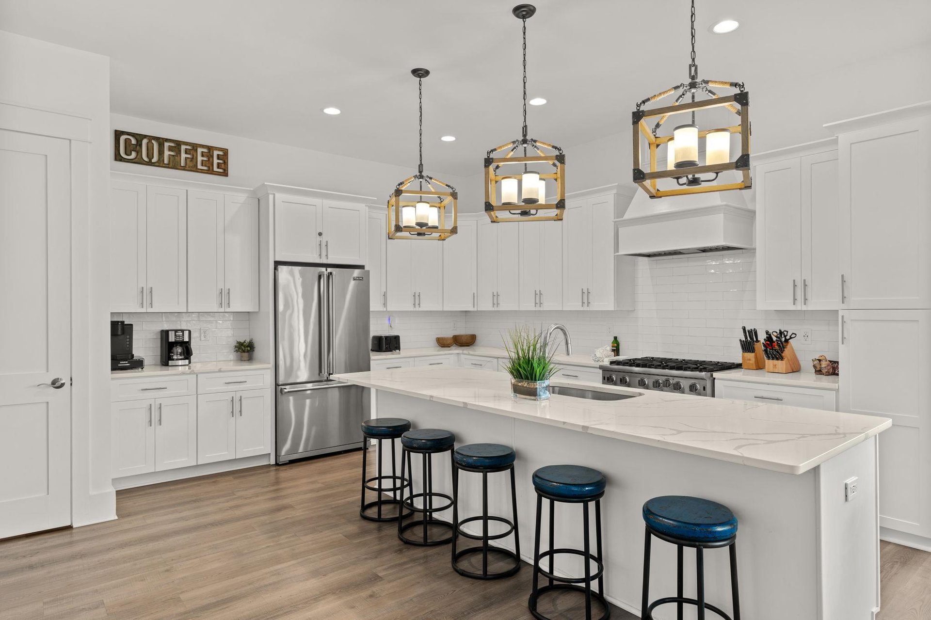 Your gourmet kitchen awaits with sleek white cabinetry, modern stainless appliances, and a spacious island—perfect for morning coffee or preparing memorable meals together.
