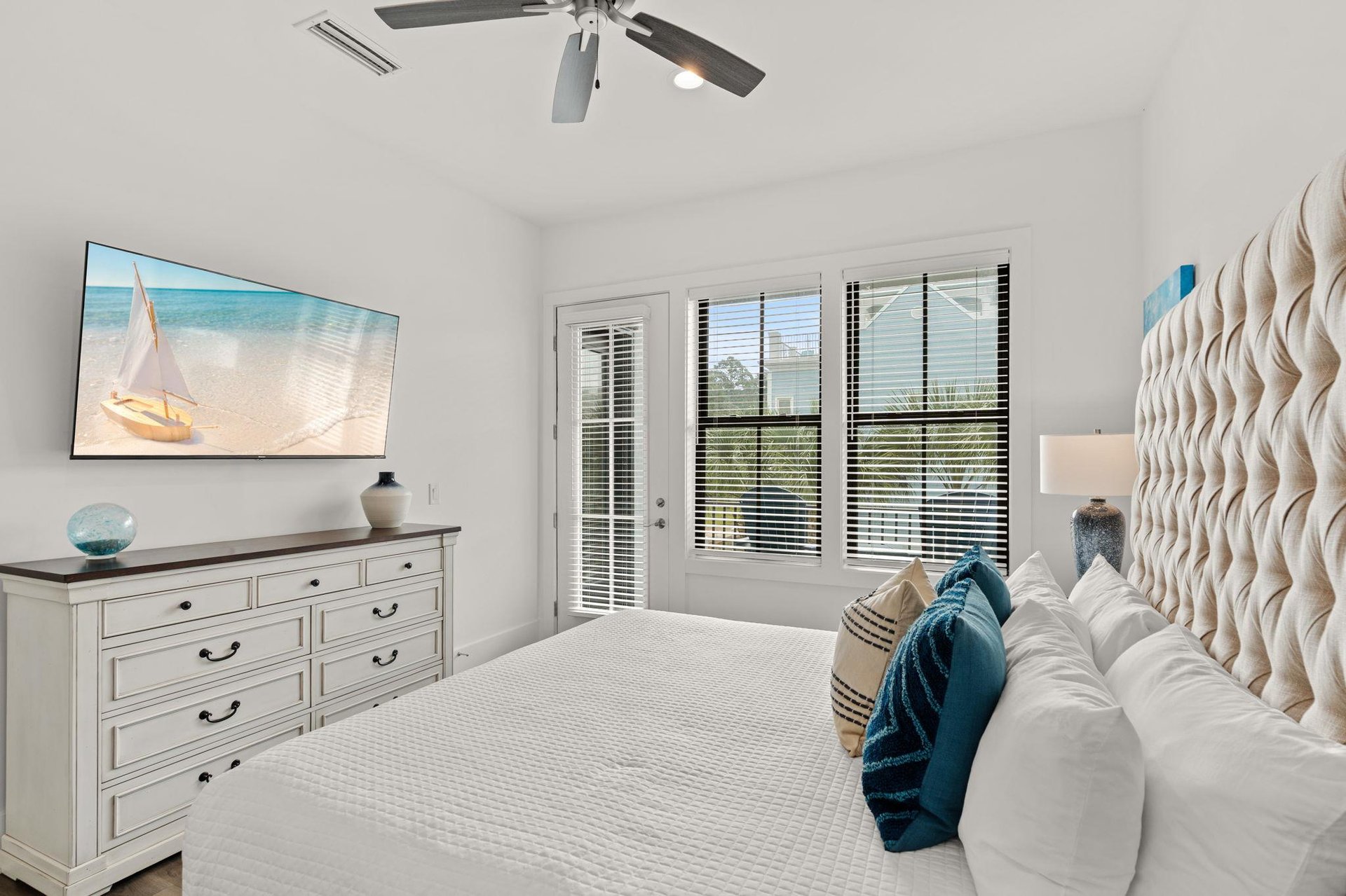 2nd floor bedroom 1 Drift off in this serene coastal bedroom with its comfortable king bed, beautiful tufted headboard, and gentle ceiling fan keeping you cool