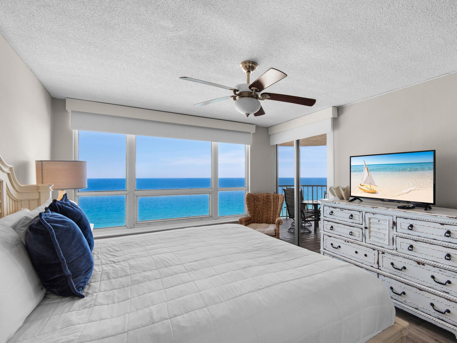 Your bedroom features a plush bed, coastal décor, and direct balcony access to enjoy the sea breeze.