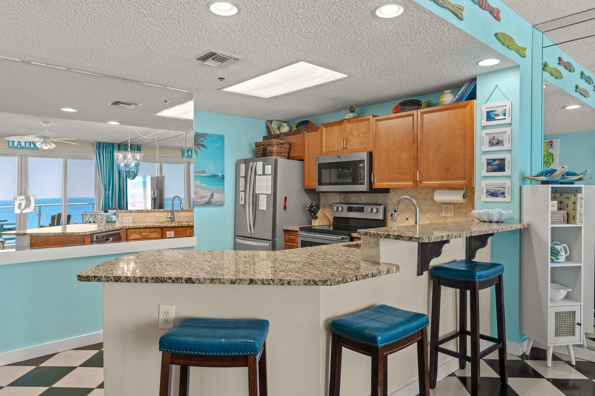 The kitchen invites culinary adventures with modern appliances and turquoiseteal decor that captures the coastal vibe