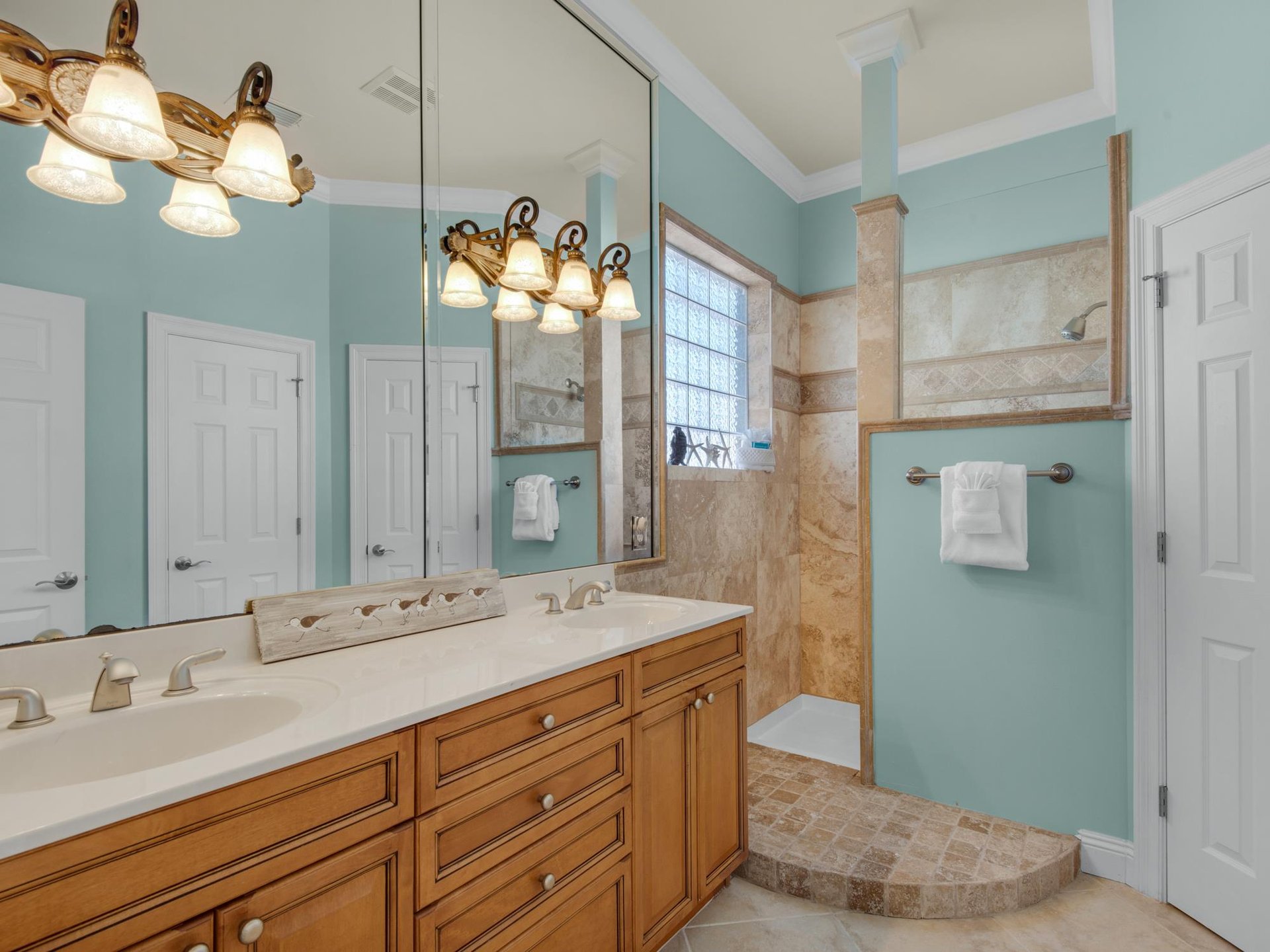 The 2nd floor bathroom features soothing aqua tones and a spacious walk in shower and double vanities.