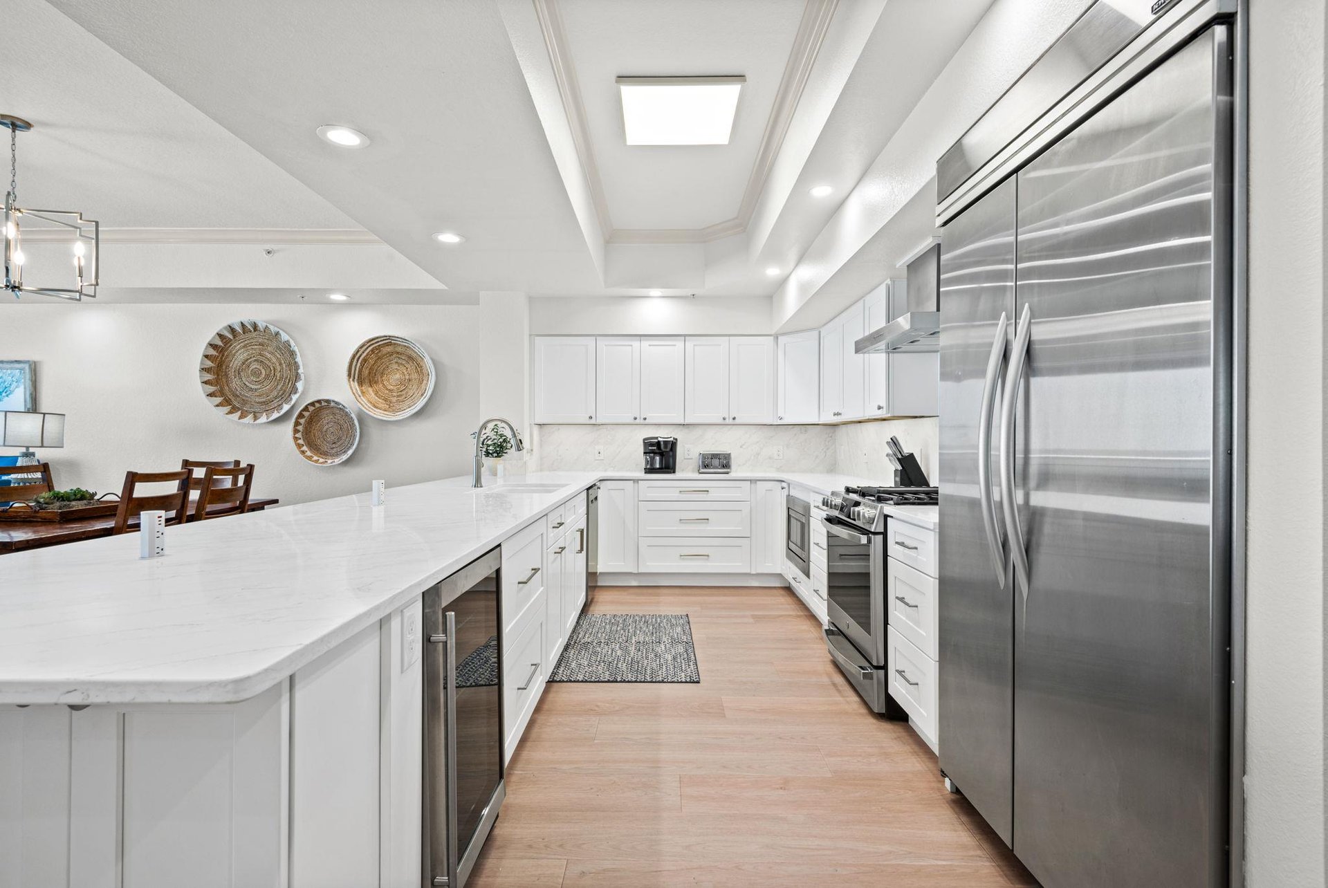 Gather, cook, and create memories in this bright, fullyequipped kitchen featuring stainless steel appliances, quartz countertops.