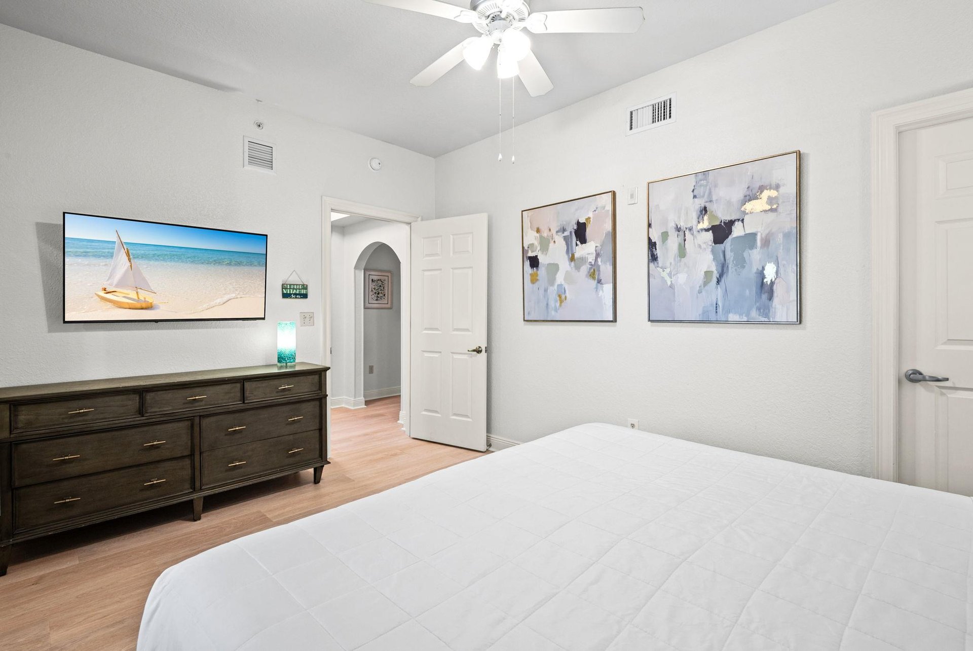 Unwind in the bright, airy bedroom with a plush bed, stylish coastal décor, and a flatscreen TV.