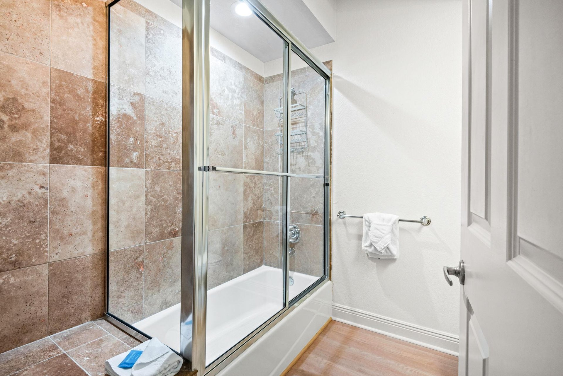 Step into the bathroom, where warm terracotta tiles embrace a spacious walkin shower.
