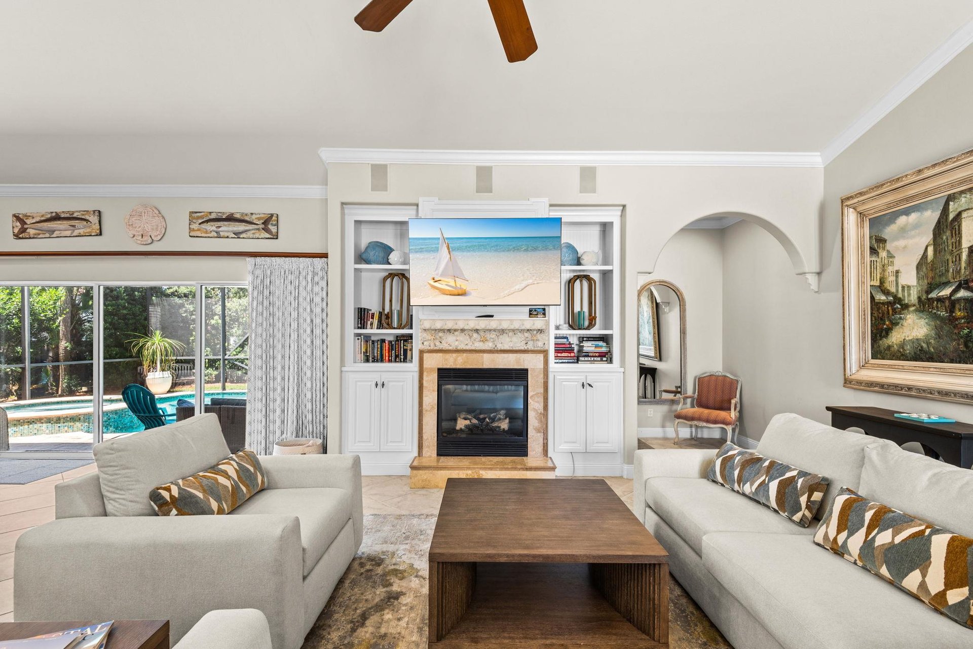 Settle into the bright living room, where beachy artwork and a cozy fireplace set the scene