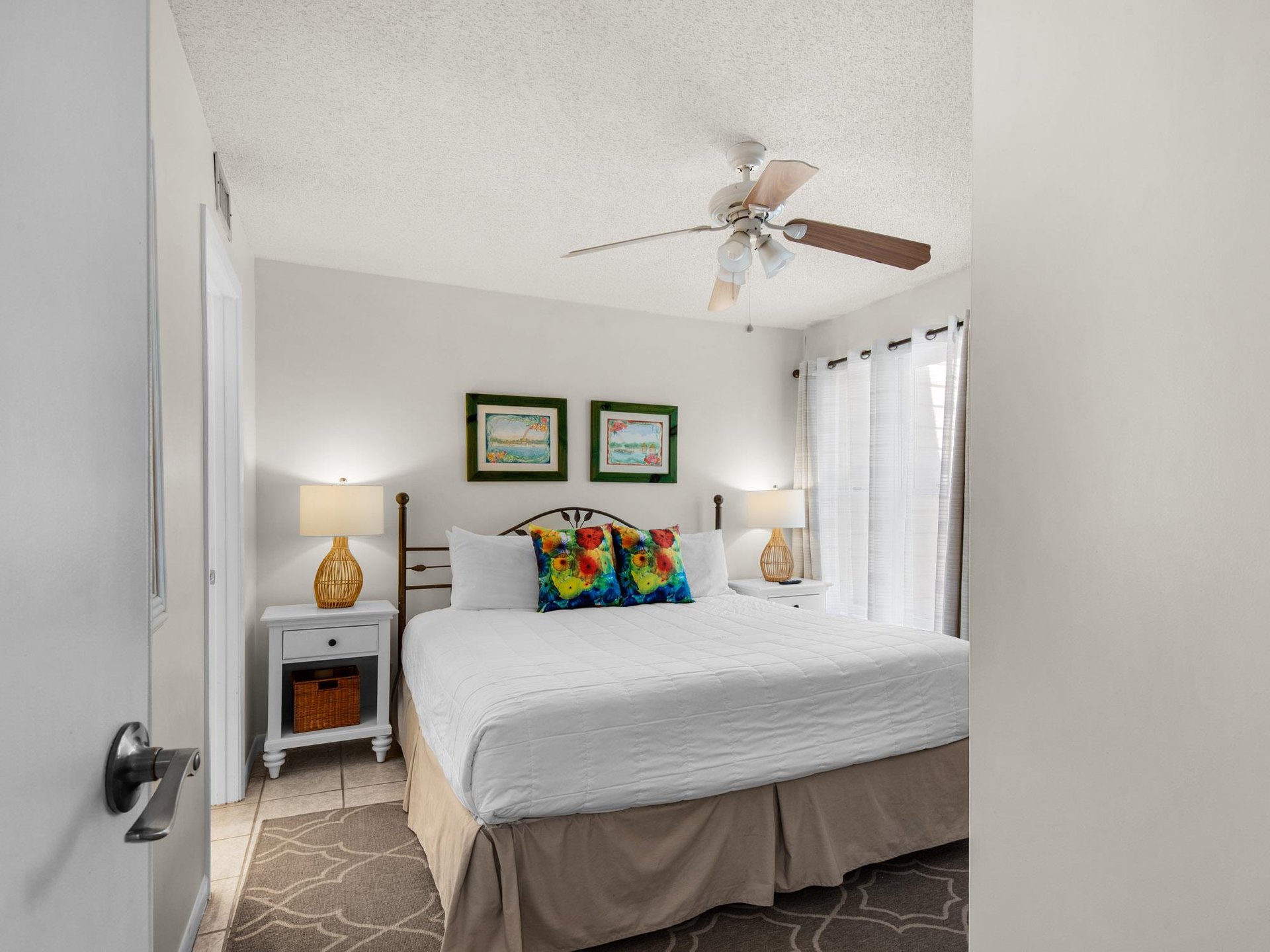 Sink into crisp linens and plush pillows in your private bedroom. A ceiling fan keeps you cool, while warm lamps and coastal artwork create a relaxing retreat after a day of adventure.