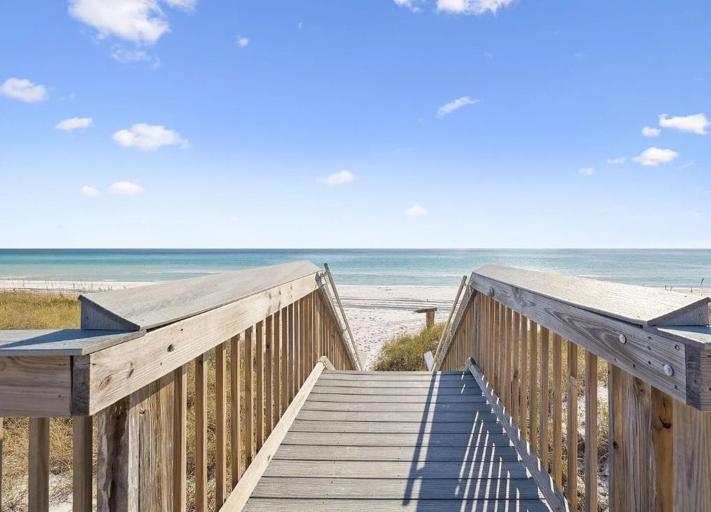 Private boardwalk leads directly to pristine white sand beach and crystalclear turquoise waters under sunny skies, offering easy access to your coastal escape.