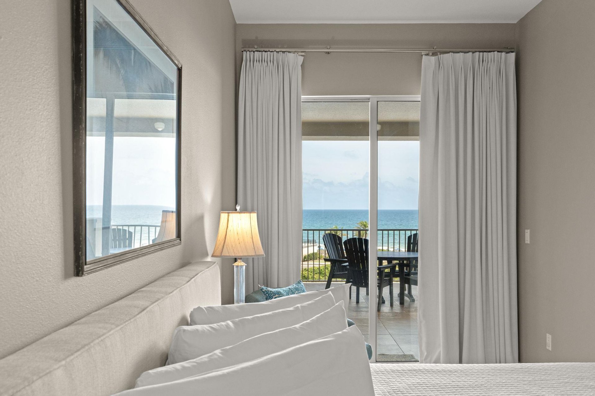 Wake up to peaceful ocean views from your bed. Soft curtains frame sliding doors leading to your private balcony, where morning coffee awaits overlooking endless blue water.