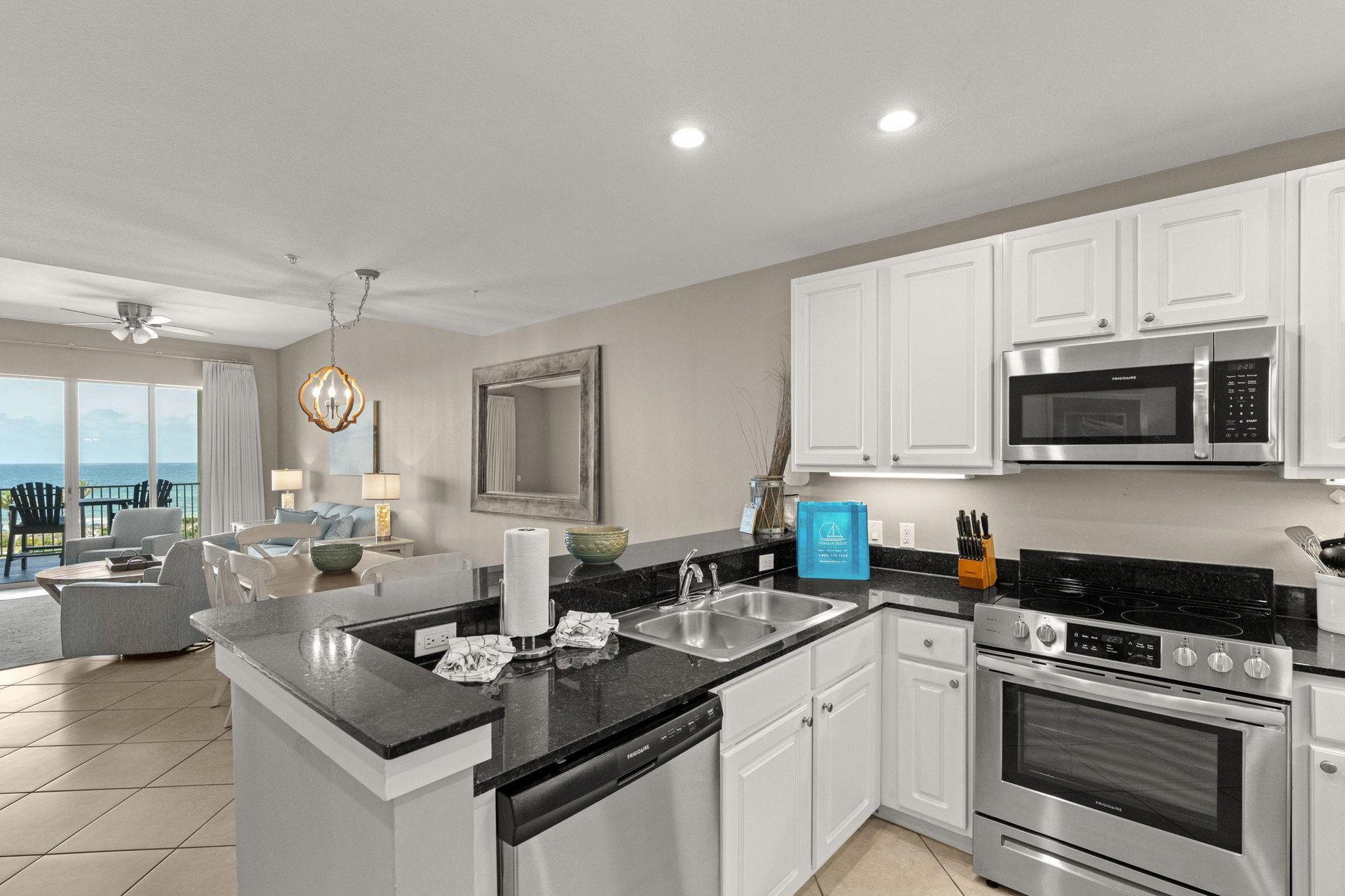 Bright kitchen with modern appliances flows seamlessly into your living area, where panoramic ocean views and soft coastal light create the perfect backdrop for meal prep and relaxation.