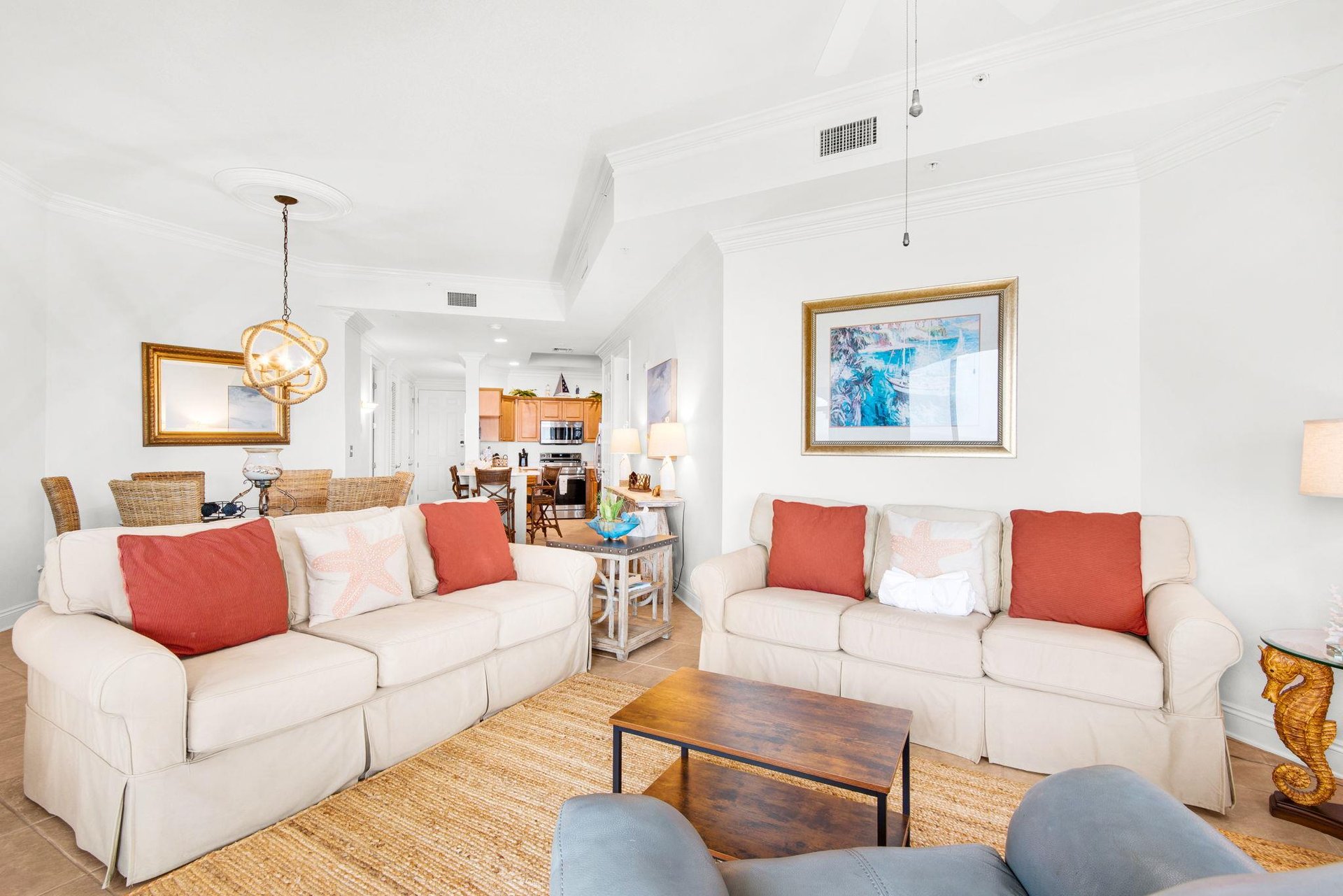 Sink into plush seating where natural textures and pops of coral invite you to unwind after sunsoaked beach days.