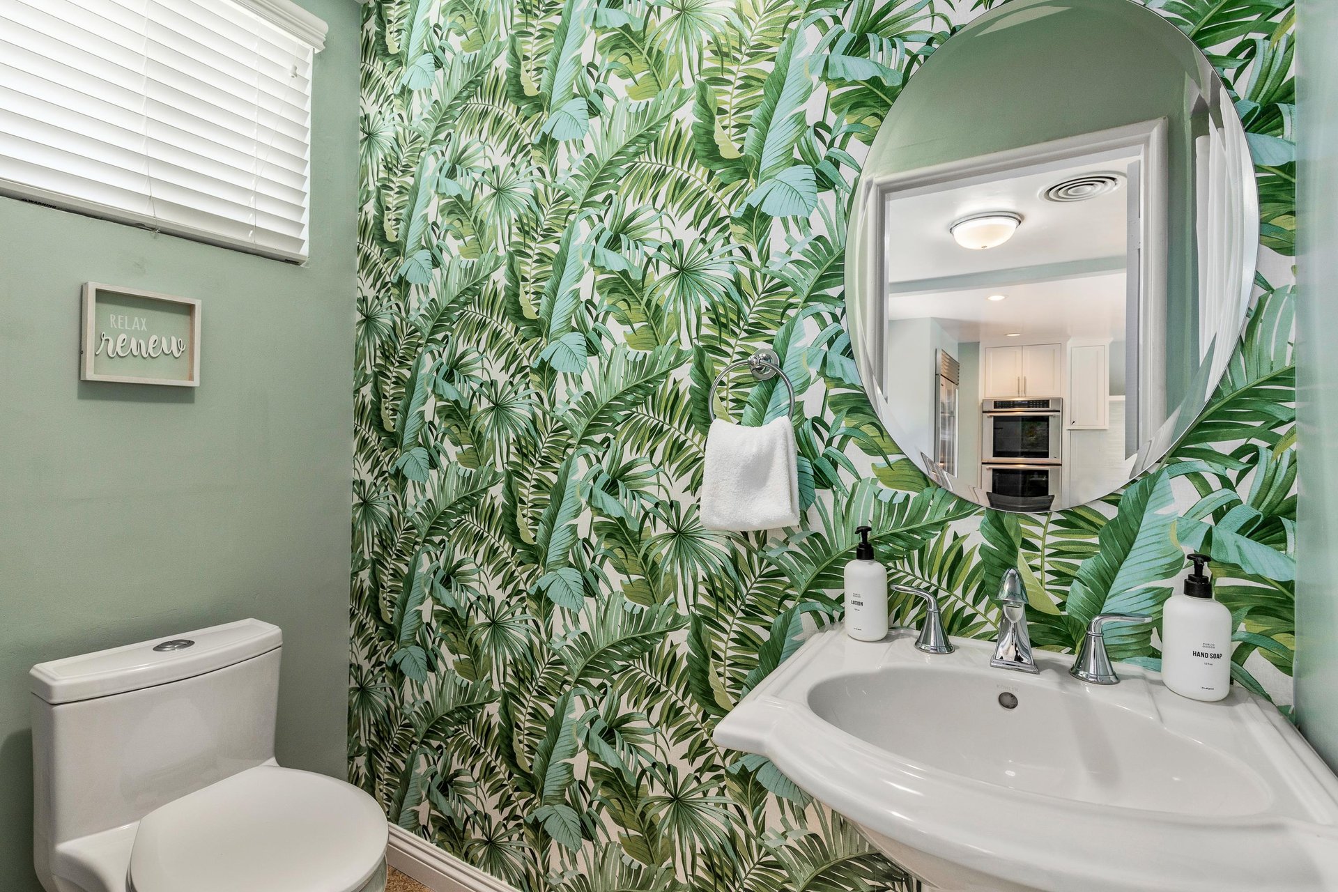 Guest bathroom adorned in lovely green wallpaper