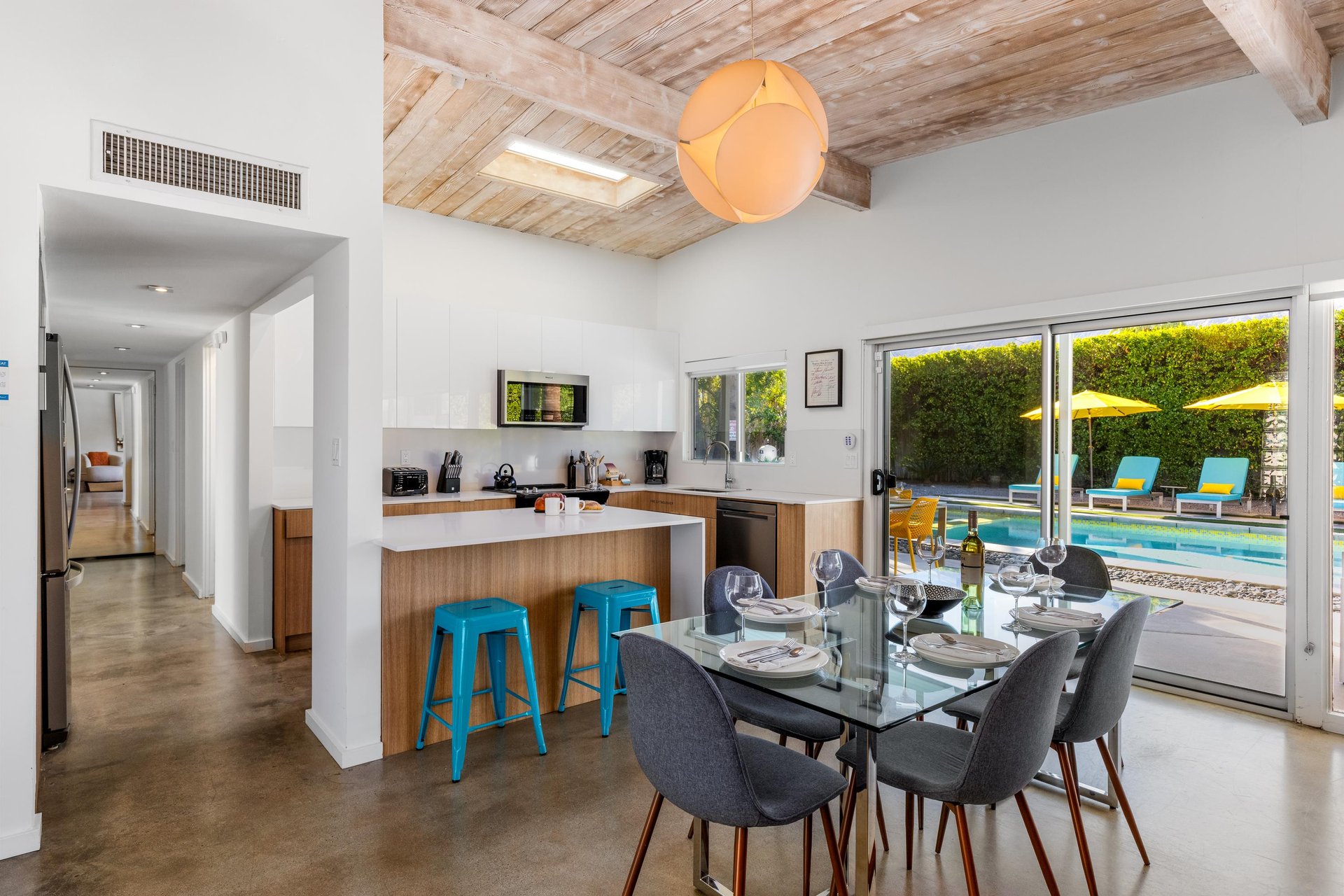 Your openconcept kitchen flows seamlessly to the dining area, where poolside views through floortoceiling windows create the perfect backdrop for meals together.