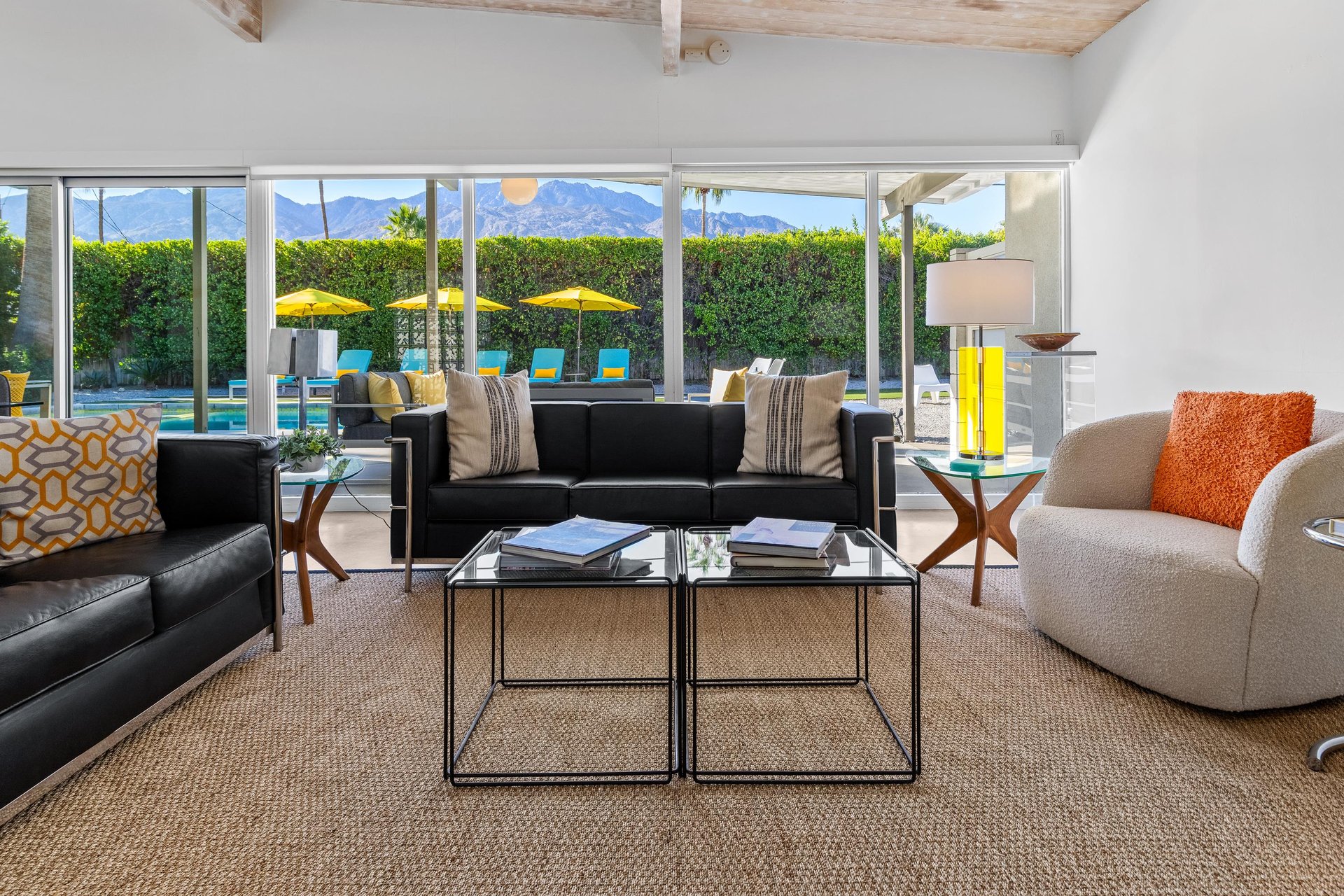 Relax in your stylish living room with soaring exposed beams and floortoceiling windows framing mountain views and pool deck.