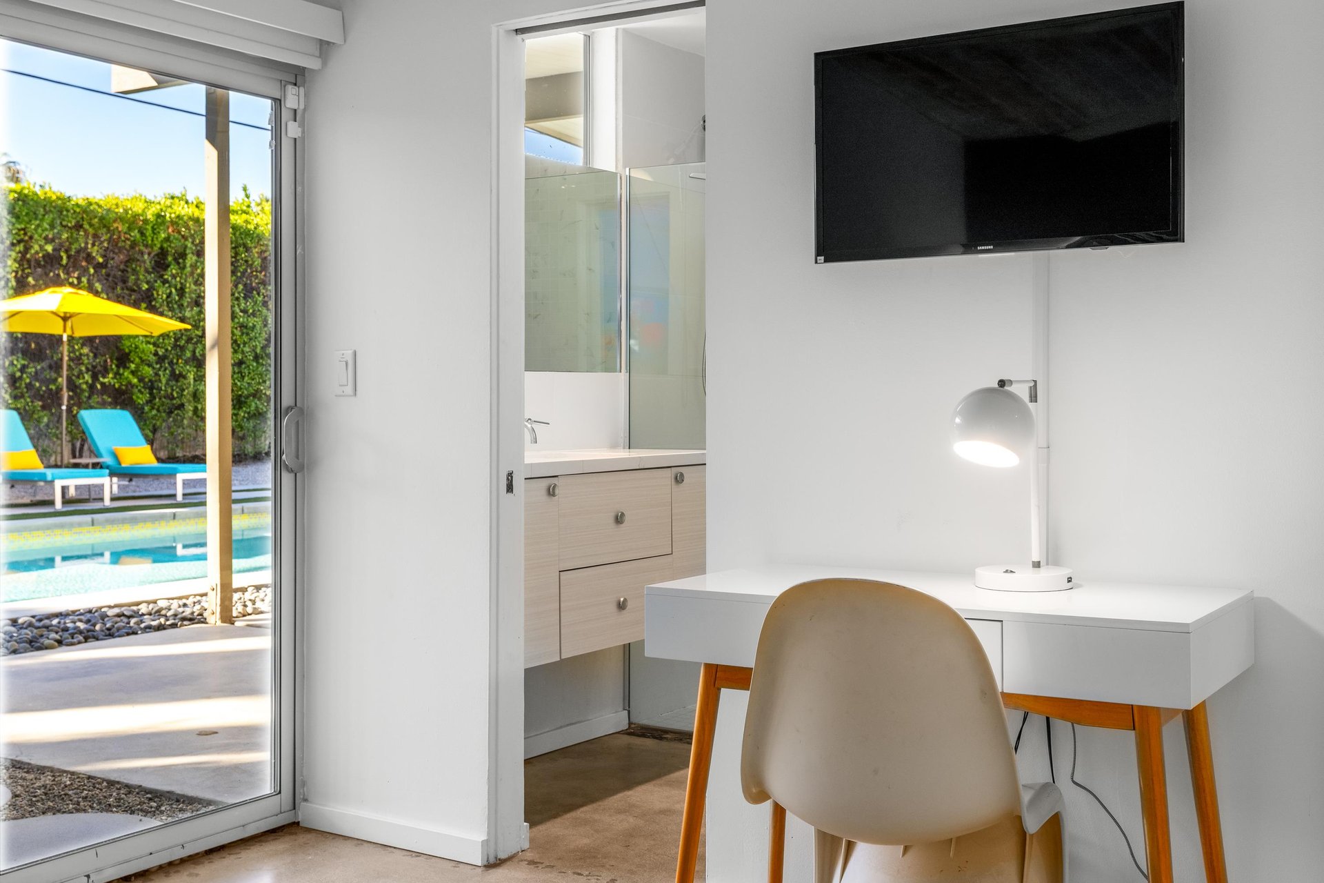 Your bright workspace overlooks the sparkling pool, perfect for catching up on emails before diving in for a refreshing swim.
