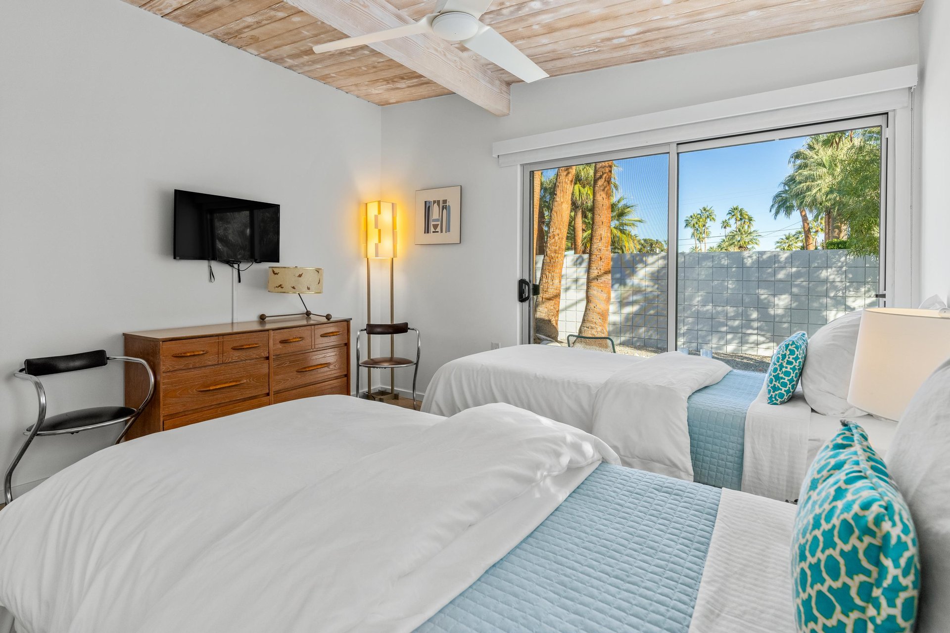 Sink into crisp linens beneath rustic wood beams, with palm trees swaying just outside your private patio doors.