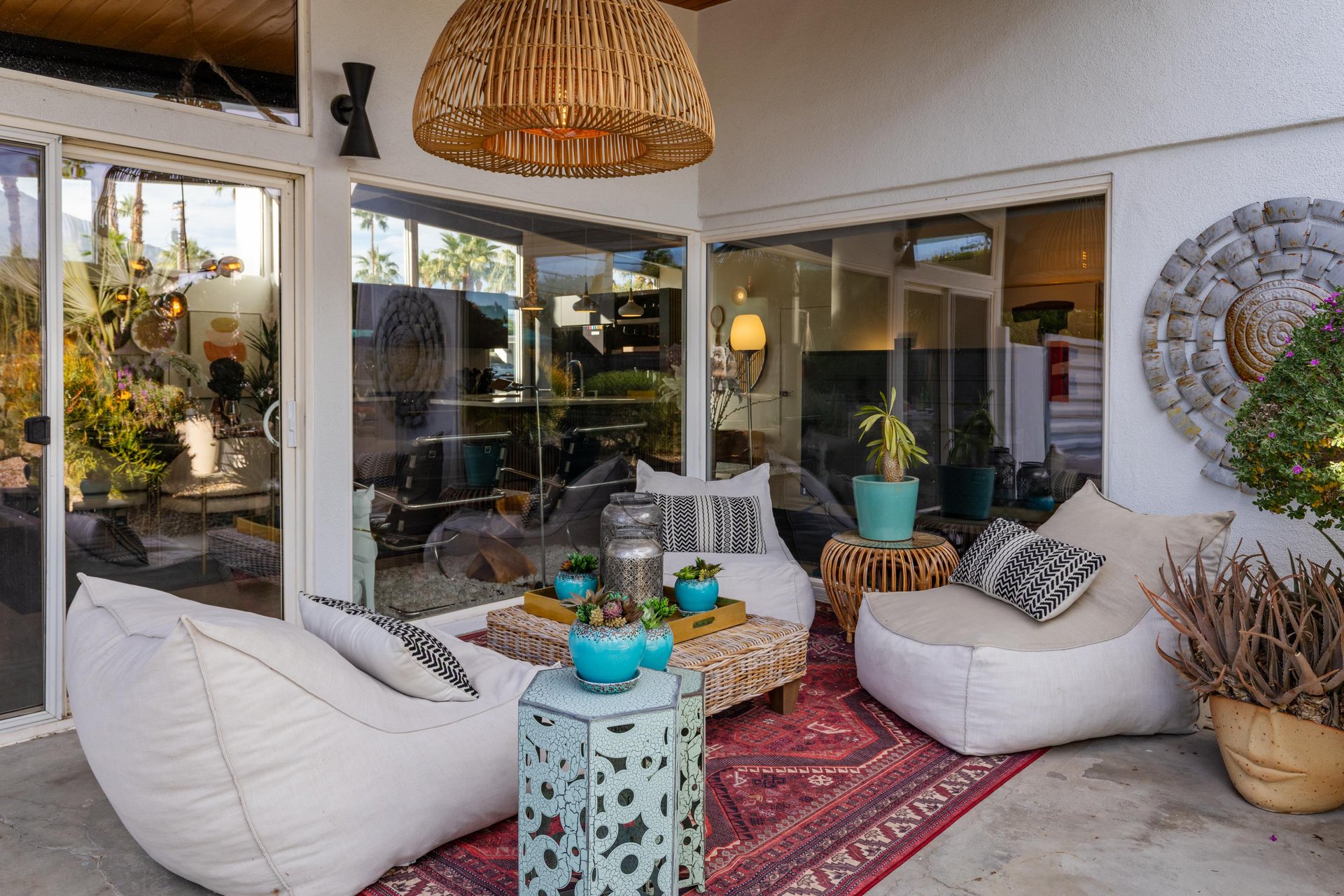 Unwind in your stylish outdoor lounge featuring plush seating, vibrant textiles, and tropical plants—perfect for morning coffee or evening relaxation.
