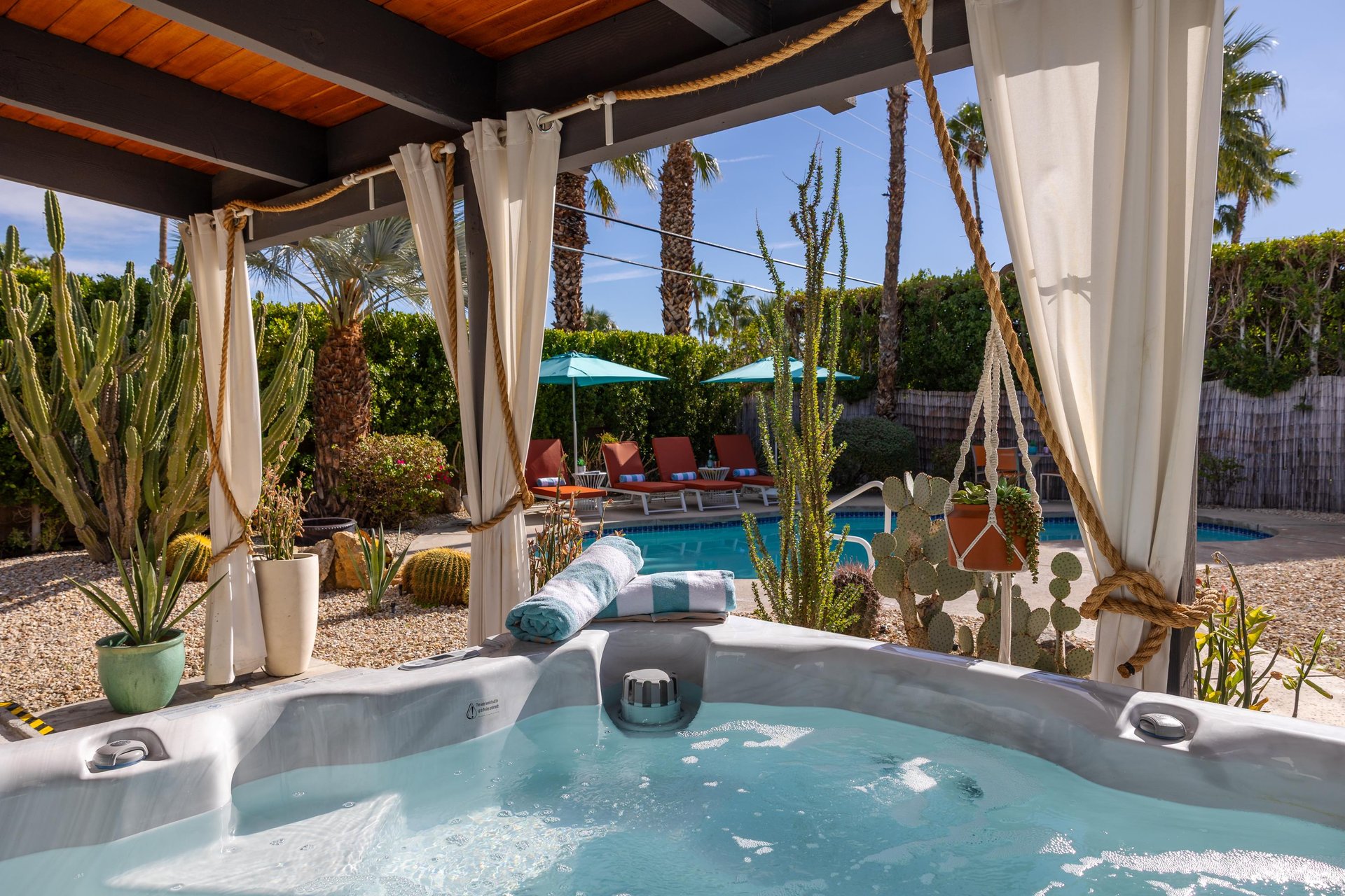 Slip into your private hot tub surrounded by desert palms and cacti, with the sparkling pool just steps away for the perfect oasis retreat.