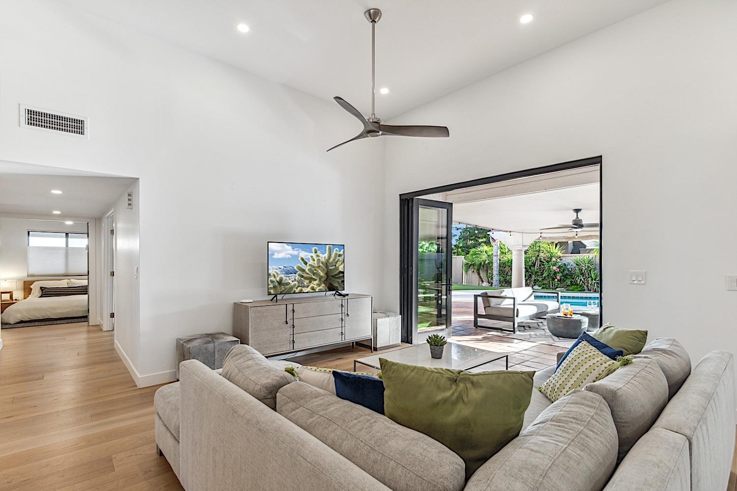 Living room has glass doors that open to the covered patioback yard