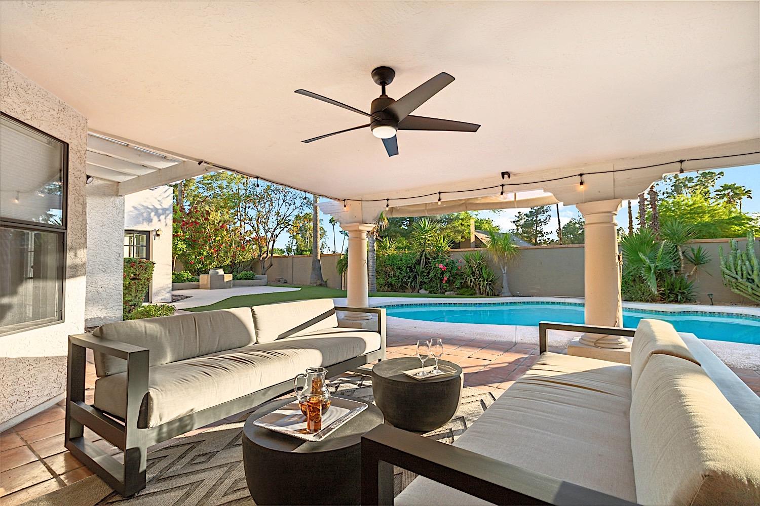 Covered patio sitting area w 2 outdoor sofas and beautiful string lights.