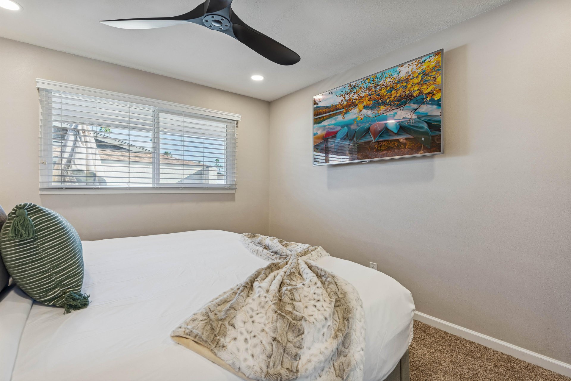 Guest bedroom with flat screen smart tv.