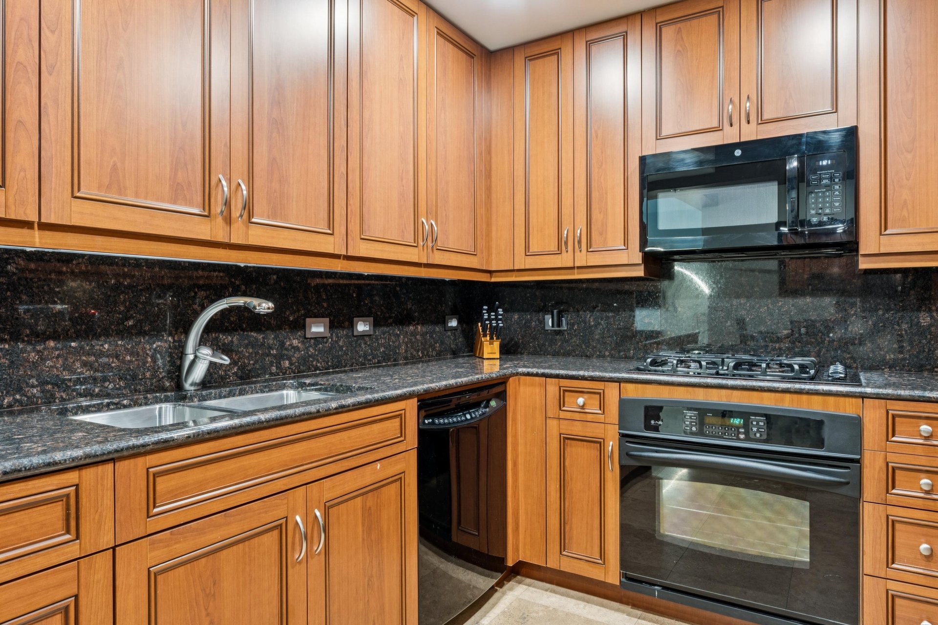 Gas stove top, with microwave oven, and dishwasher.