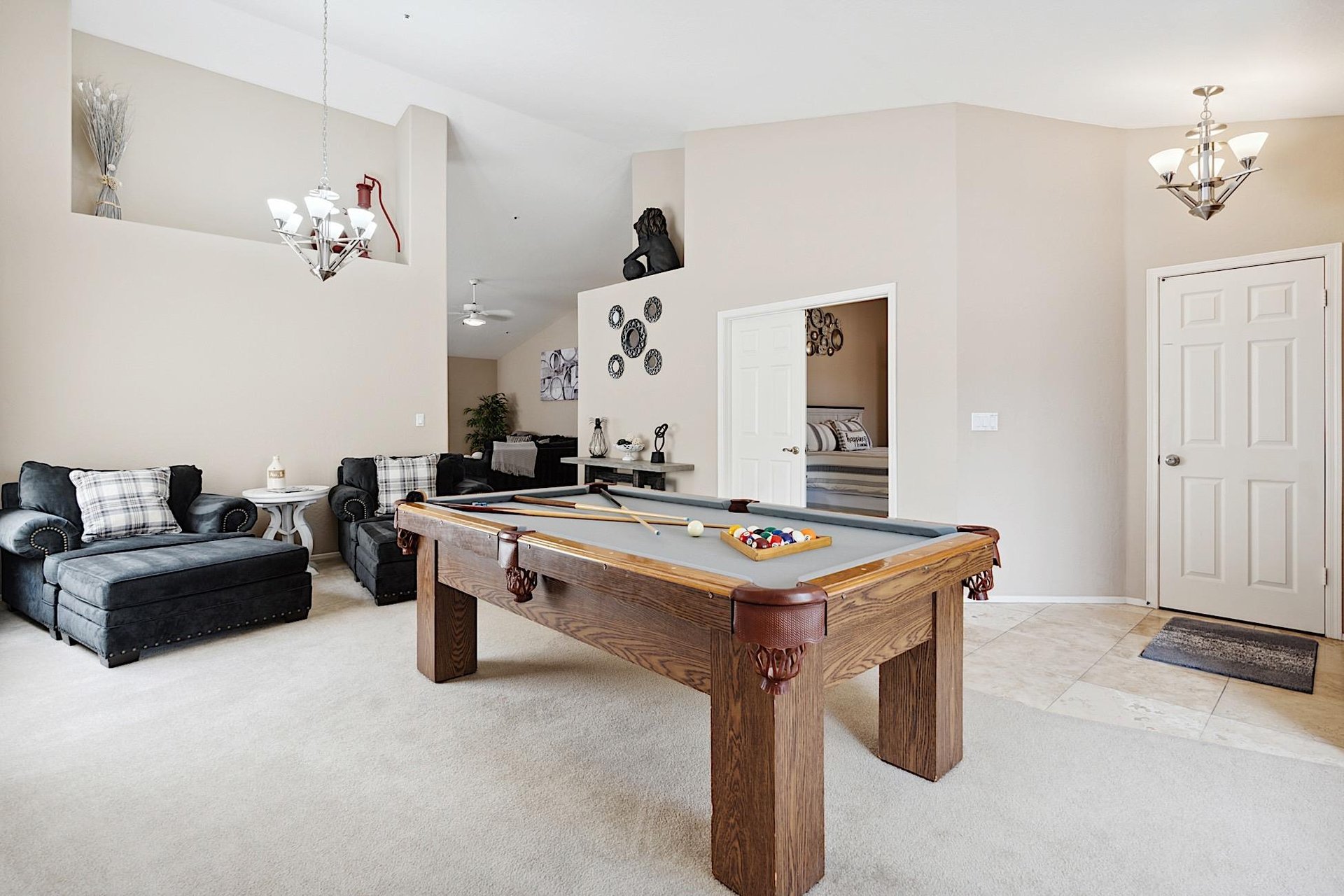 Family room has a billiard table and two oversized chairs
