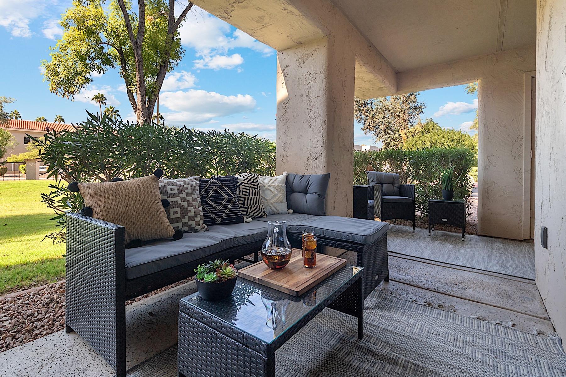 Private patio w Lshaped outdoor sofa, coffee table and two sitting chairs.