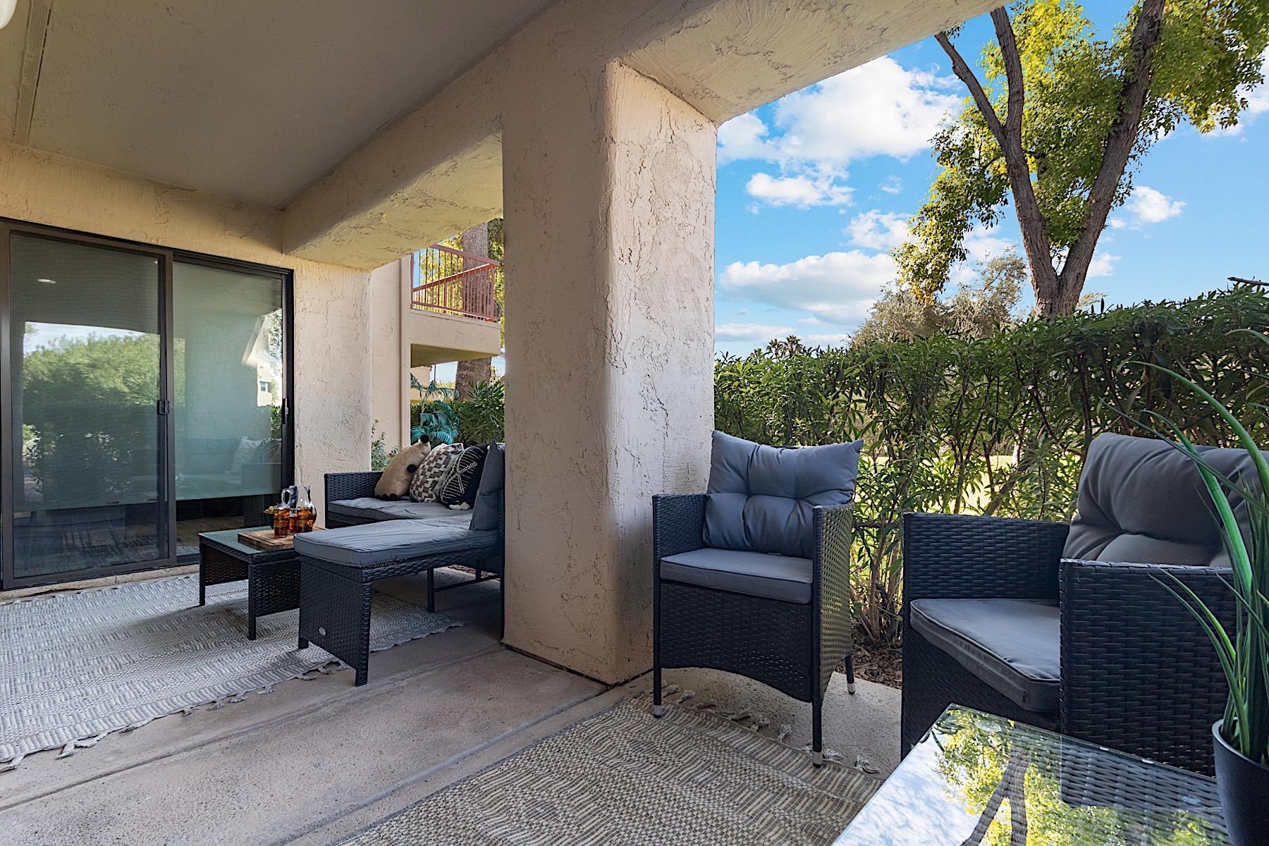 Private patio w Lshaped outdoor sofa, coffee table and two sitting chairs.
