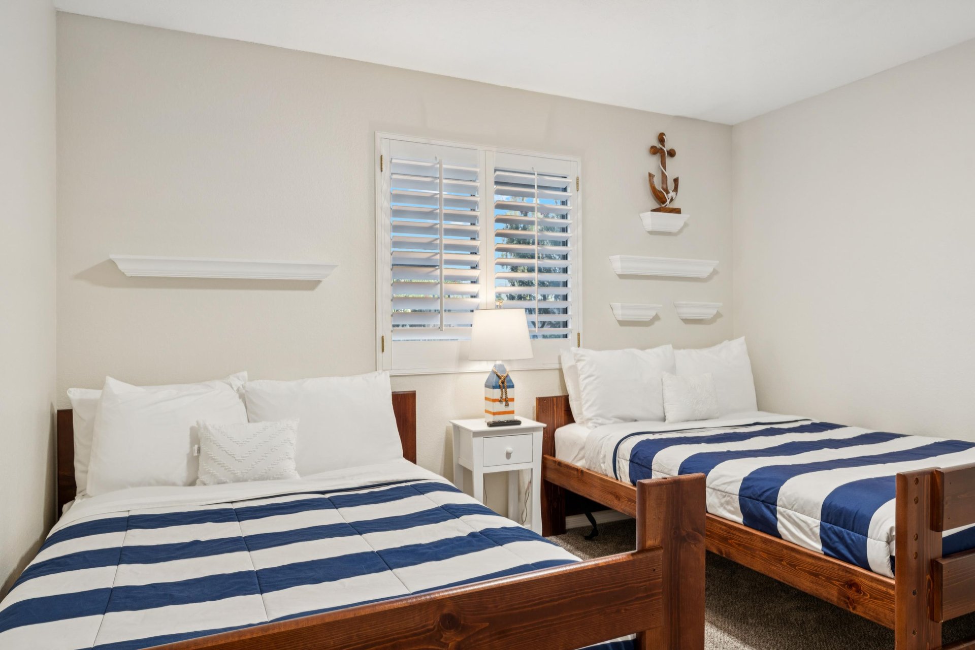 Two full sized beds with sturdy wooden bed frames and a shuttered window for when you wanna let in a little AZ sunshine