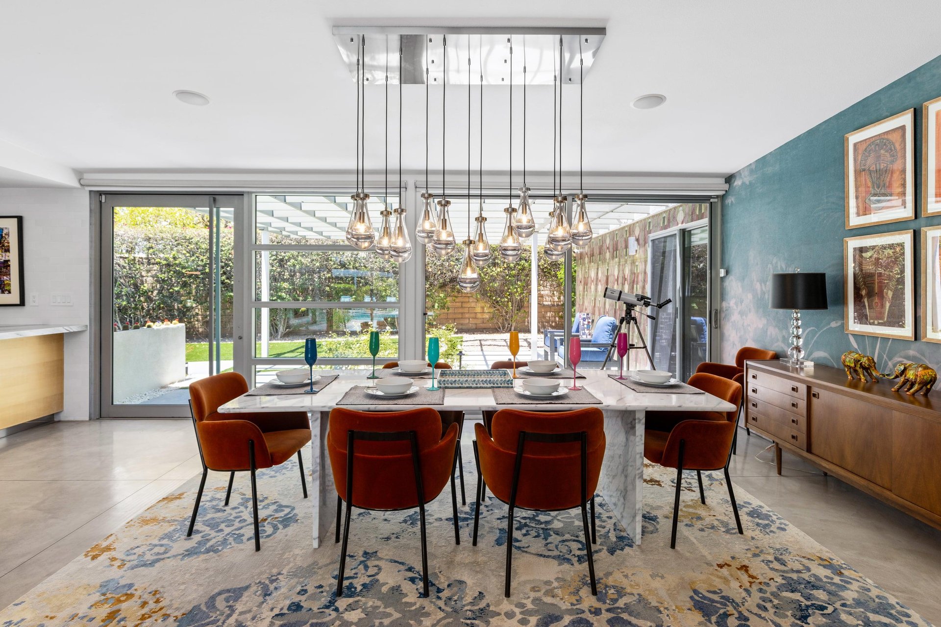 Dine at a marble table set for 6 under a beautiful chandelier. View of the front door just off to the left of the table.