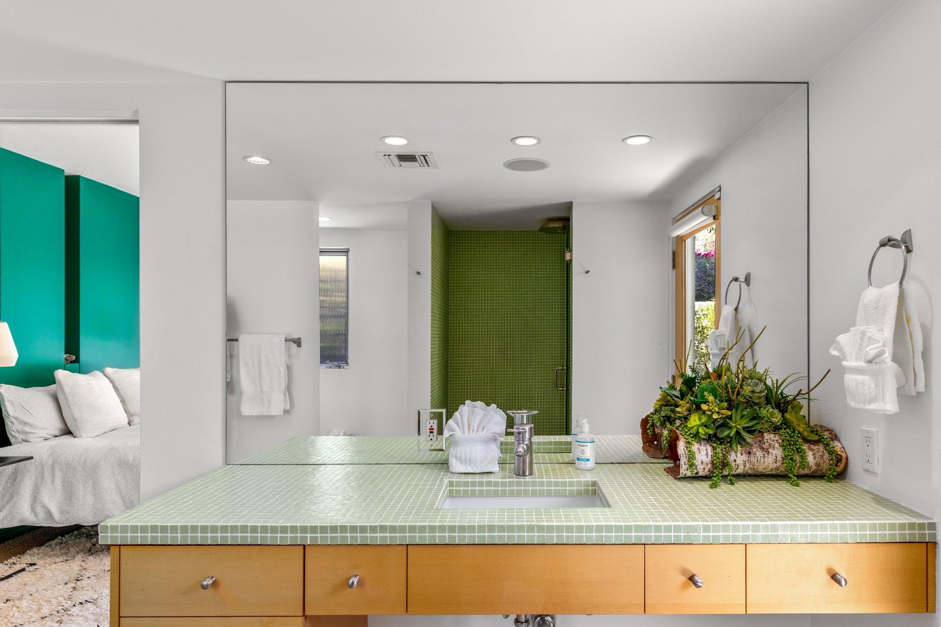 Ensuite bathroom with incredible tile, standalone shower, and door to the outside.
