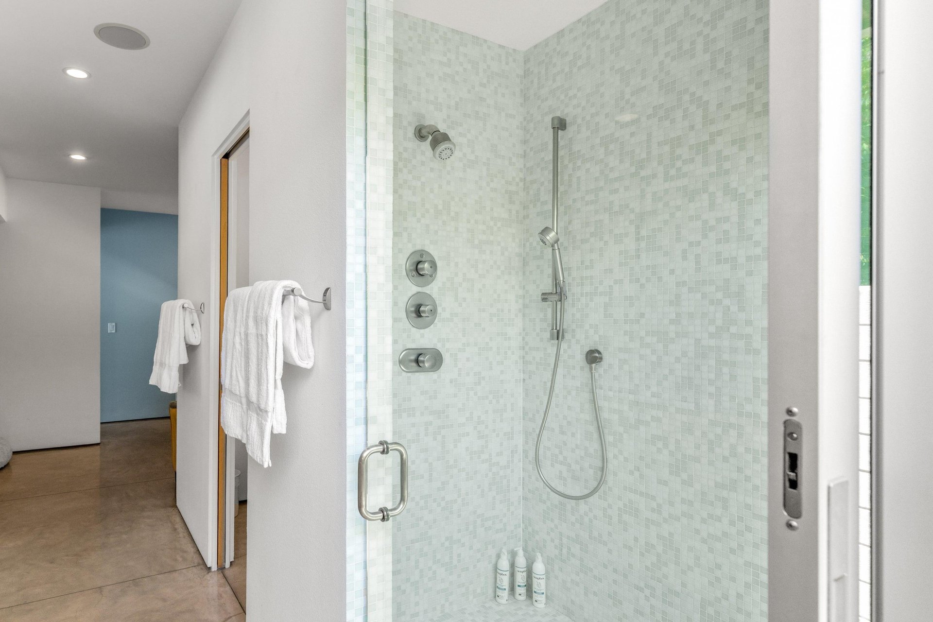 Standalone shower with its own sliding door to turn it into an indooroutdoor shower.
