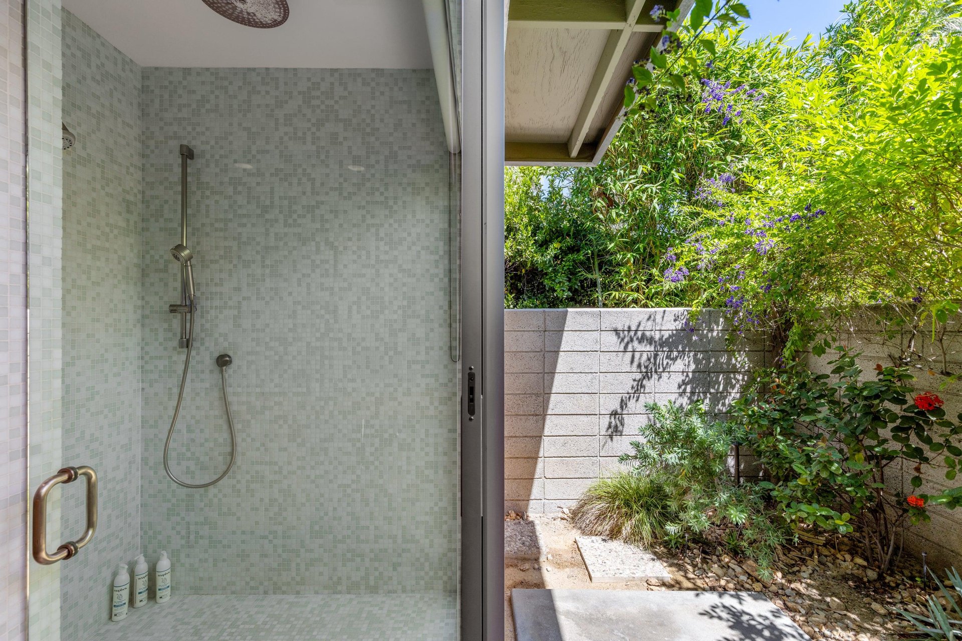 Standalone shower with its own sliding door to turn it into an indooroutdoor shower.