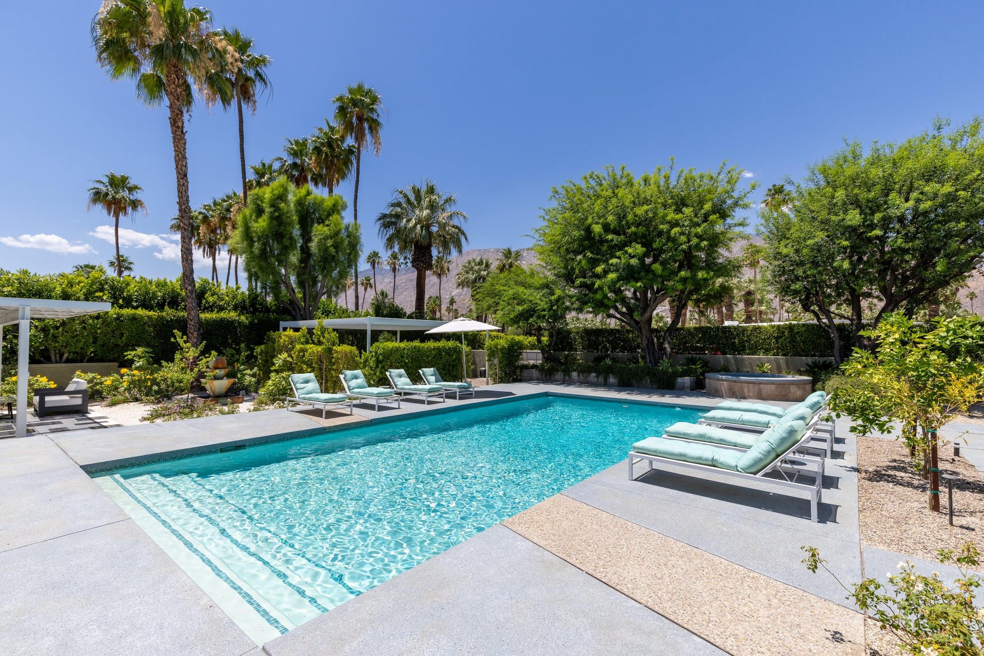 Private poolspa with sun loungers and umbrellas.