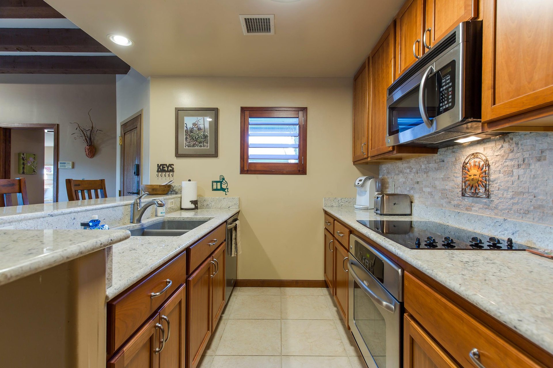 Features bartop counter seating for 2 guests, stainless steel appliances, keurig coffee maker, and kitchen essentials.
